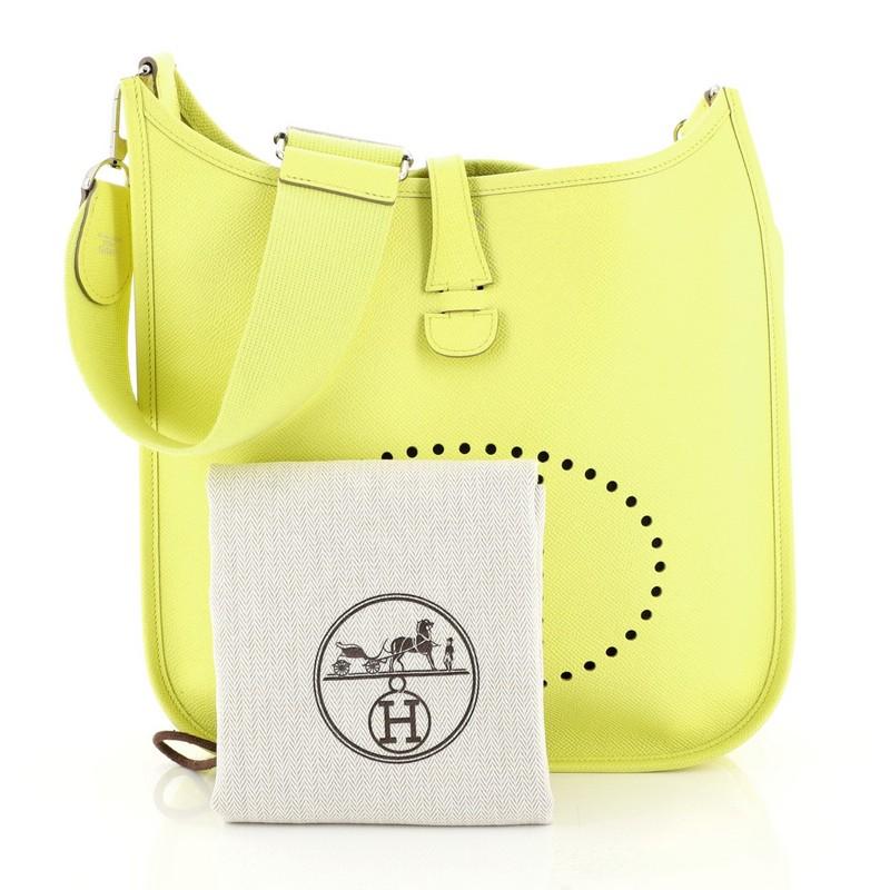 This Hermes Evelyne Crossbody Gen III Epsom PM, crafted in Soufre yellow Epsom leather, features perforated H design at the front, accessible back pocket, adjustable textile shoulder strap, and palladium hardware. It opens to a yellow raw leather