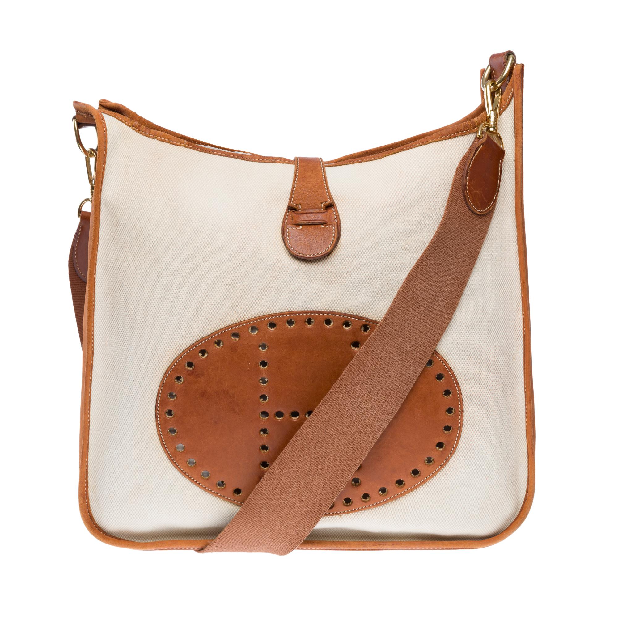Iconic​ ​Hermès​ ​Evelyne​ ​GM​ ​shoulder​ ​bag​ ​in​ ​Courchevel​ ​blue​ ​jeans​ ​leather,​ ​golden​ ​metal​ ​trim,​ ​a​ ​removable​ ​shoulder​ ​strap​ ​in​ ​blue​ ​canvas​ ​allowing​ ​a​ ​shoulder​ ​or​ ​crossbody​ ​carry

Snap​ ​button​ ​closure​
