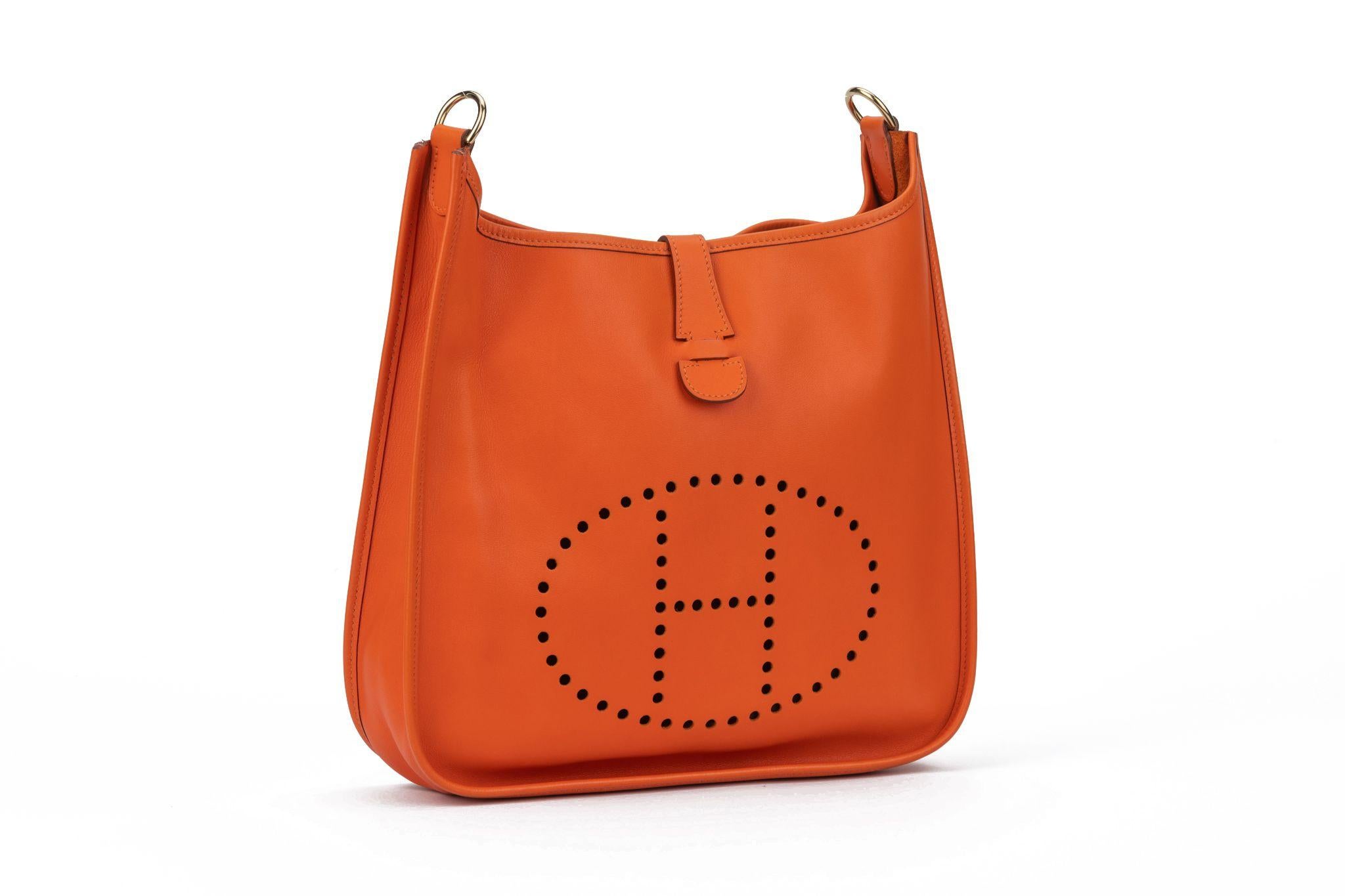 Hermès Evelyne GM featuring swift leather in orange. It comes with palladium gold hardware and has a shoulder strap made of fabric. Date stamp B in a square. The bag is in excellent condition. It comes with the original dustcover.