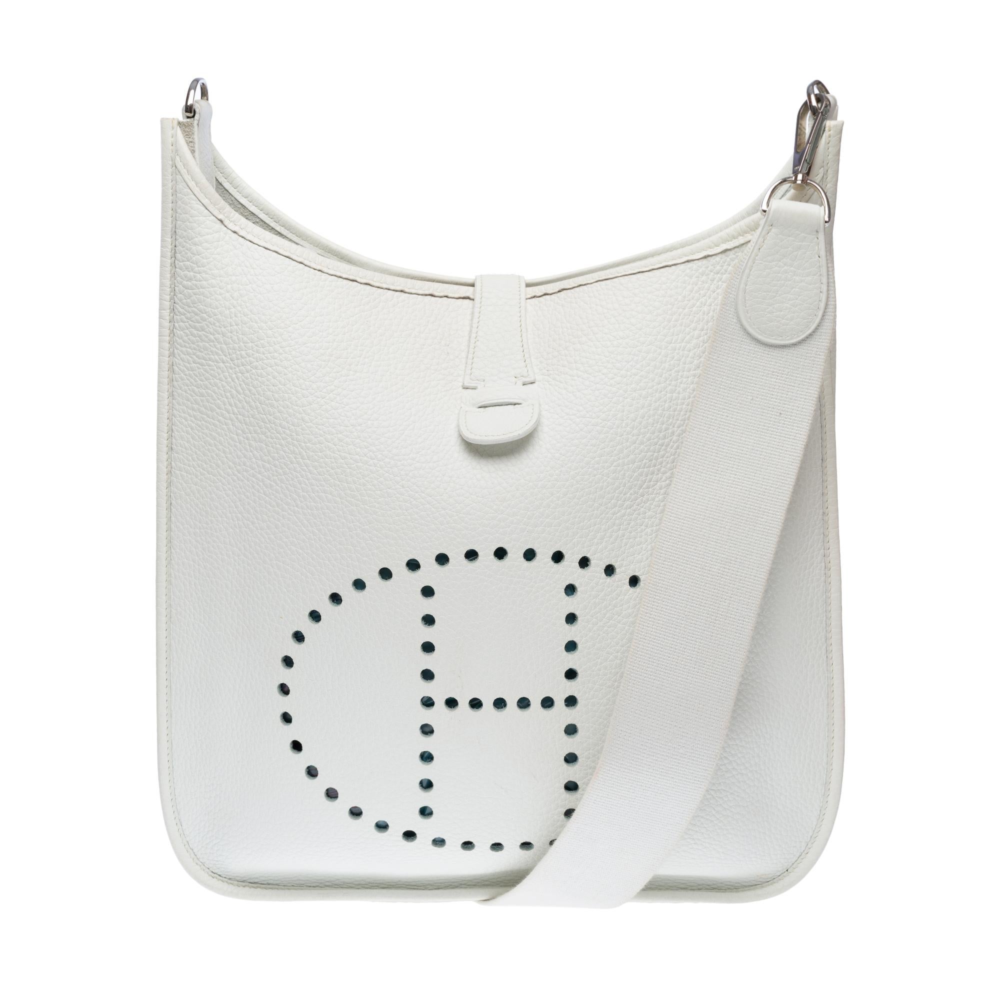 Iconic​ ​Hermès​ ​Evelyne​ ​II​ ​GM​ ​shoulder​ ​bag​ ​in​ ​white​ ​Togo​ ​calf​ ​leather,​ ​silver-tone​ ​metal​ ​trim,​ ​a​ ​removable​ ​white​ ​canvas​ ​shoulder​ ​strap​ ​allowing​ ​for​ ​shoulder​ ​or​ ​crossbody​ ​carry

Closure​ ​with​ ​snap​