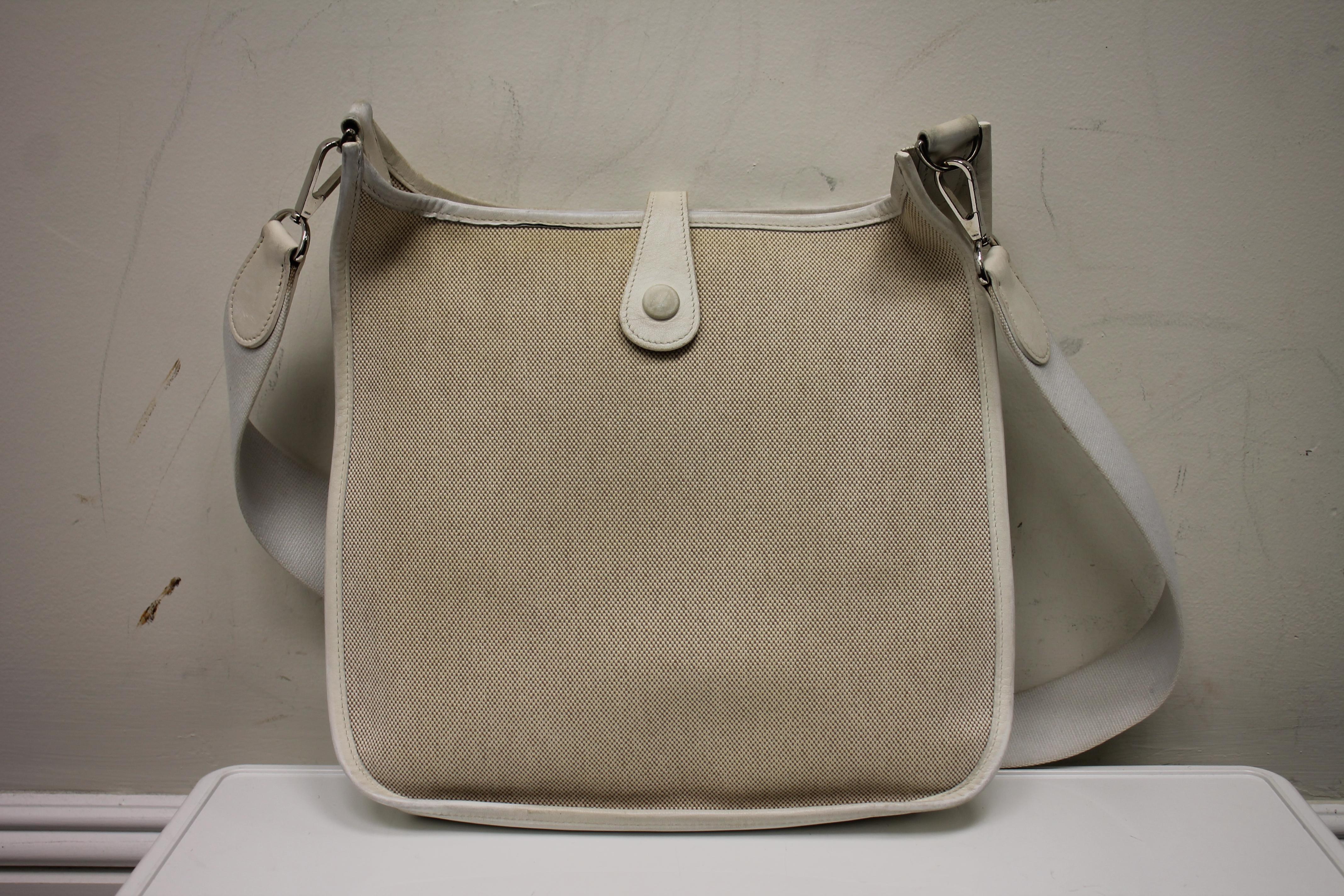 White leather and natural canvas. Palladium hardware. Snap closure at top. Perforated 