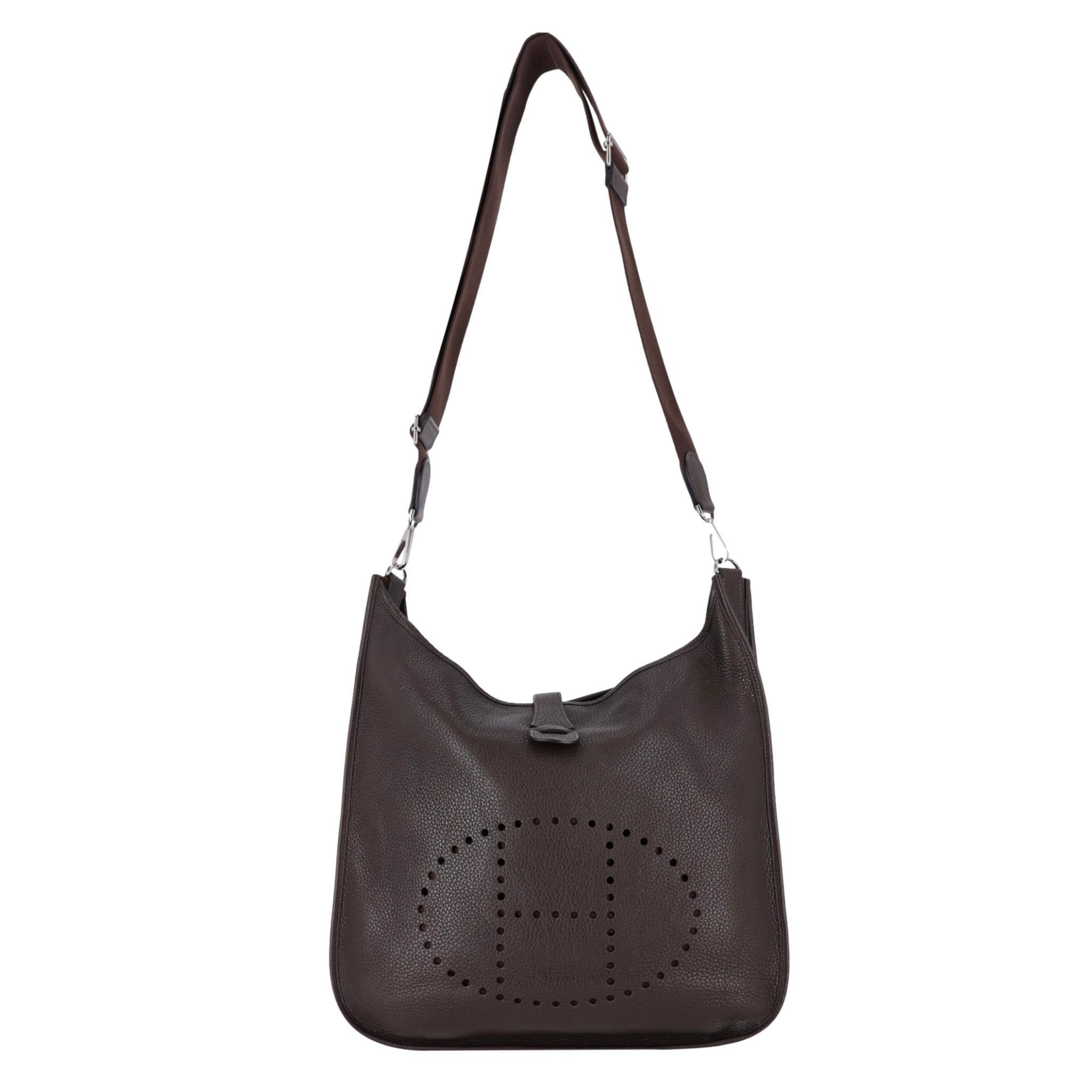 Hermes Evelyne Taurillon Clémence TGM Leather Shoulder Bag

This highly sought after piece is crafted from Taurillon Clémence leather in chocolate brown.

Branded palladium hardware and signature perforated 'H' logo to the centre.

Leather tab