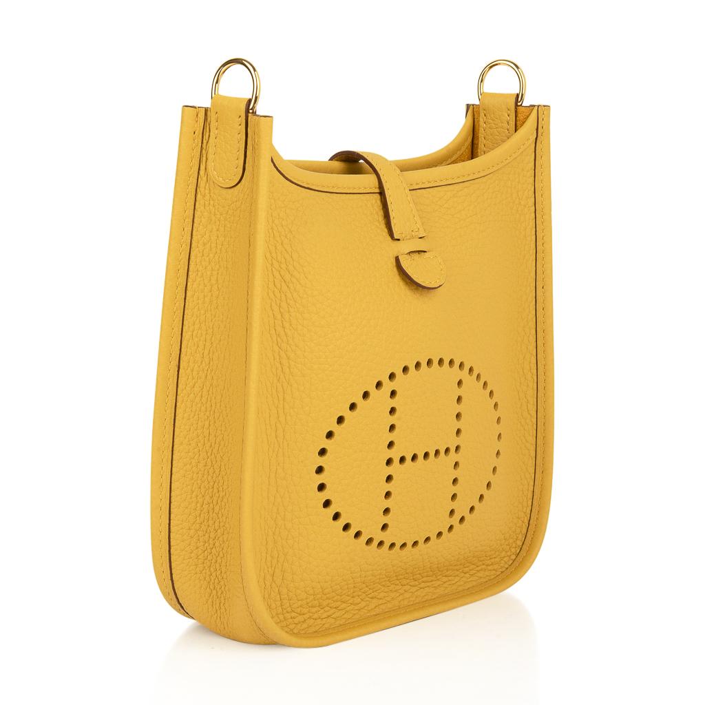 Guaranteed authentic Hermes Jaune Ambre Hermes Evelyne TPM bag features rare gold hardware.  
Clemence leather is soft and scratch resistant.
Signature perforated H on front of bag.
Fabulous shoulder or cross body bag. 
Sport strap in textile with