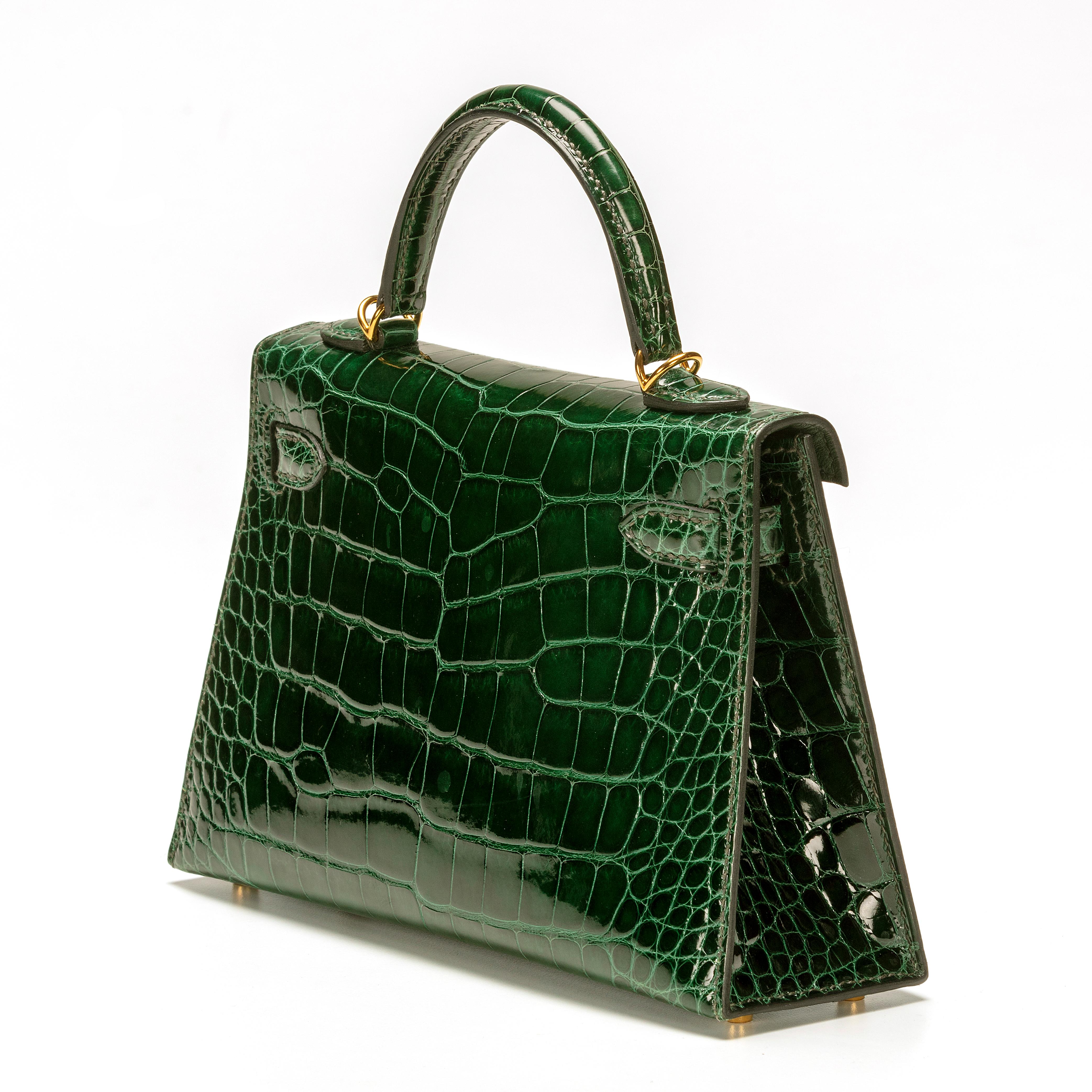 This Gorgeous Hermès Mini Kelly is extremely sought after. Featured in Vert Foncé a Dark Green exotic leather exterior with Gold Hardware and a green leather interior including a slip pocket. The bag incorporates a front flap with a turn lock
