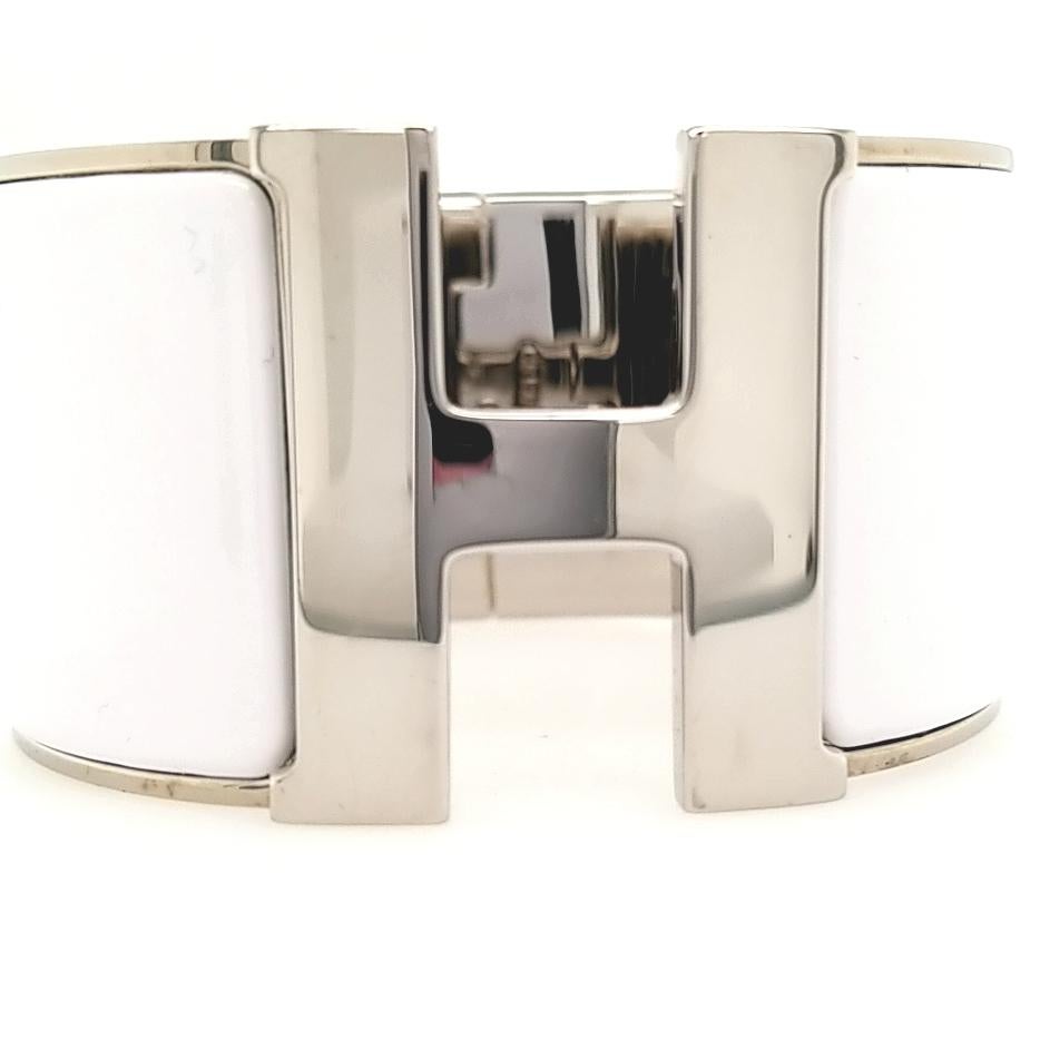 Hermès extra wide Clic Clac H bracelet in white enamel with H closure and palladium plated hardware in size PM. Diameter: 2.25