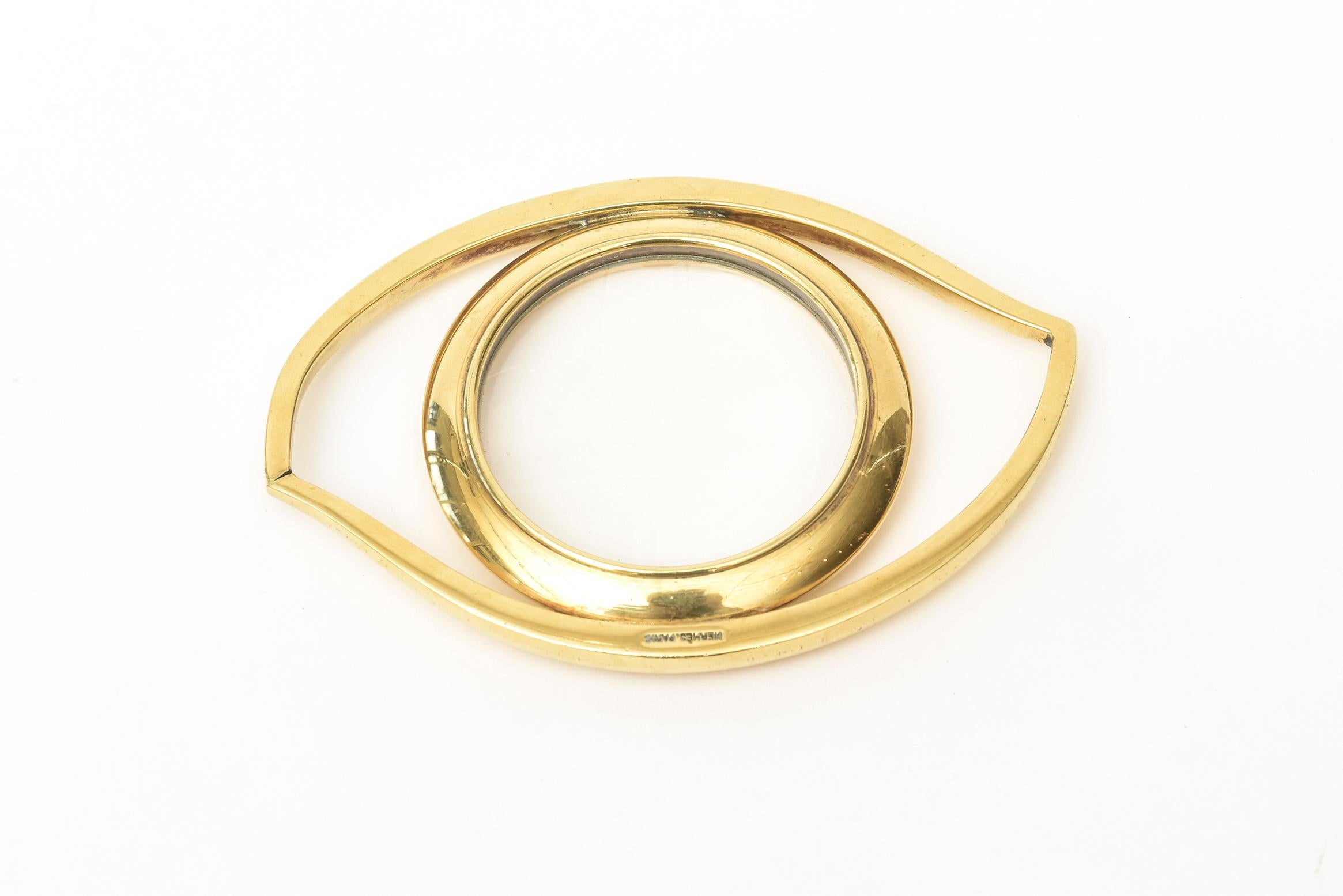 This always conversational and clever signed Hermes Cleopatra eye magnifier and or paperweight is gold-plated and glass. It is vintage from the 1960s. It was designed by Jean Cocteau for Hermès in the 1960s. The influence was based on Egyptian