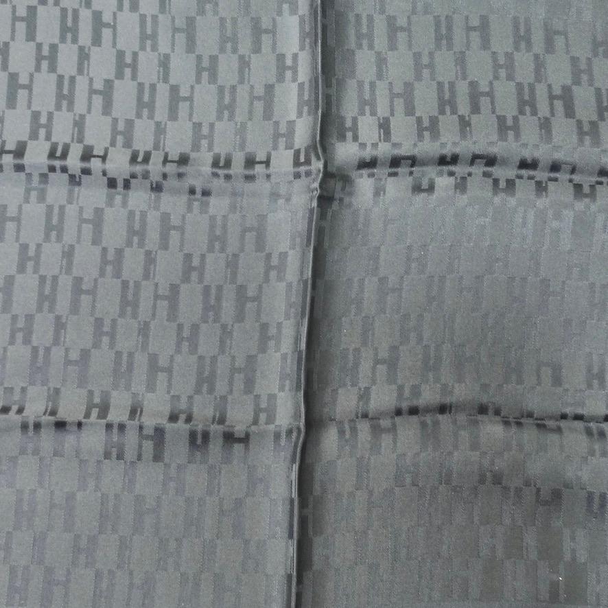 Ne manquez pas ce superbe foulard en soie Hermès datant des années 1990 ! Ce foulard sobre et raffiné, d'un gris éclatant, est orné du monogramme signature d'Hermès. 100% soie jacquard, cousu à la main et bords roulés ! Préparez-vous à ne jamais