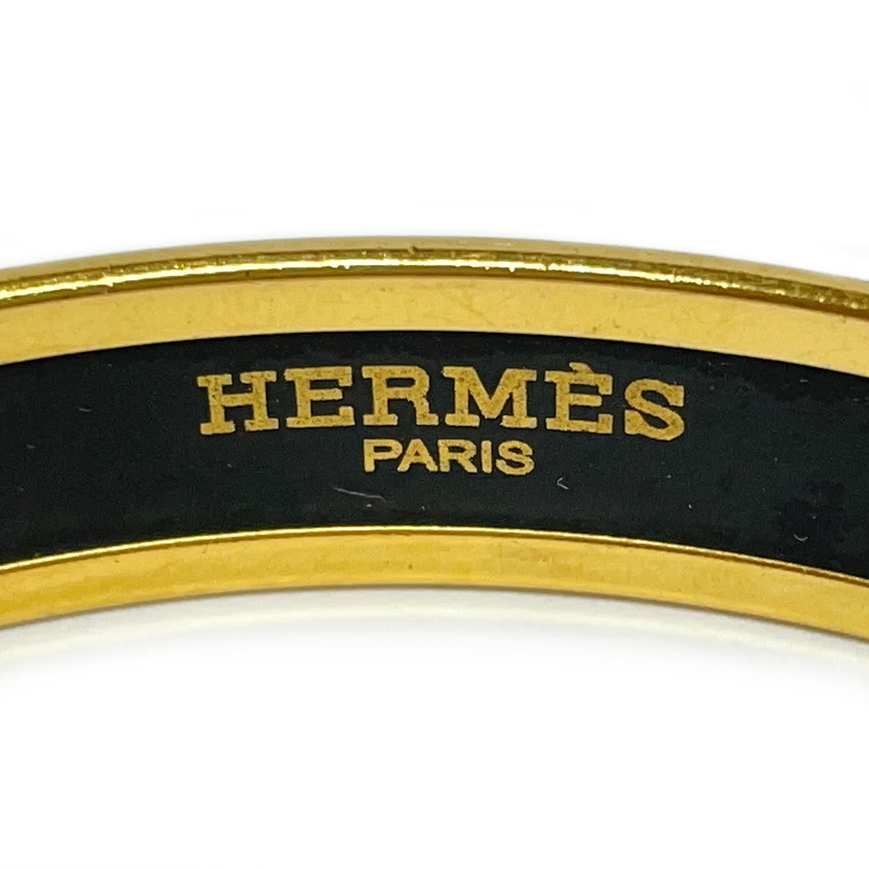 Hermes Fan Grand Alpala Cloisonne Enamel Black and Gold plated bangle bracelet. This chic bangle features classic Hermes motifs; rope, tassels, and, Fleur de Lis. The bangle has an all-around smooth finish. The bangle measures 10.4mm wide, with an