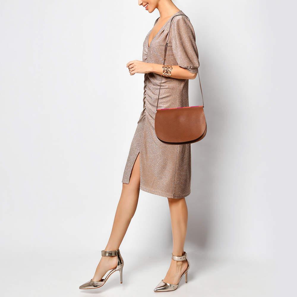 Experience fine craftsmanship with this immaculately designed leather bag by Hermes. It has a half moon shape flap closure and a long strap.