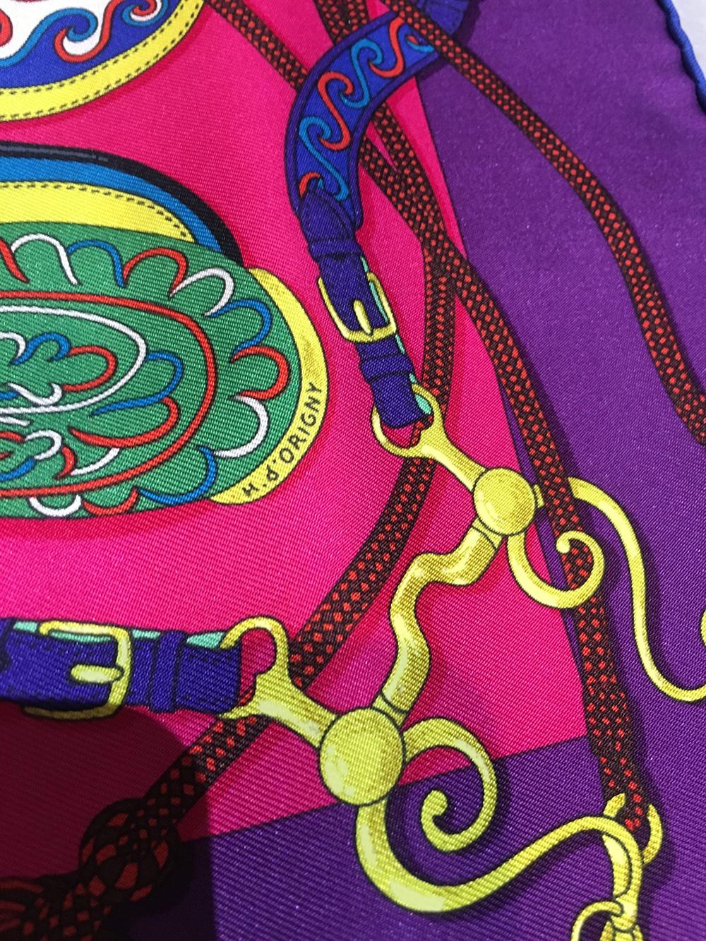 Hermes Festival des Amazones Silk Pocket Square in excellent condition. Original silk screen design c1992 by Henri d’Origny features a colorful assortment of horse saddles in orange, green, blue with yellow and red accents over a fuchsia pink