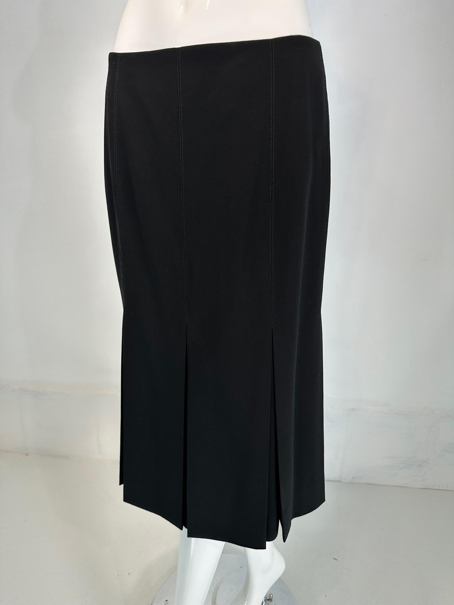 Hermes fine black 100% wool stitch down pleated skirt. Hermes classic, fine black wool skirt with seam waist, deep stitch down pleats that open below the hip. The skirt closes at the waist back with a hidden tab button, zipper closure. Unlined all