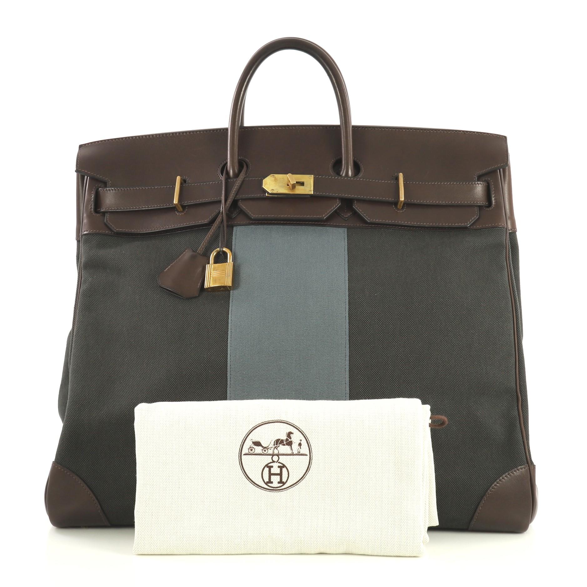 This Hermes Flag HAC Birkin Bag Toile and Evercalf 50, crafted in Multicolor Toile H and Toile Galon and Ebene brown Evercalf leather, features dual rolled handles, front flap, and brass hardware. Its turn-lock closure opens to a Graphite Toile H