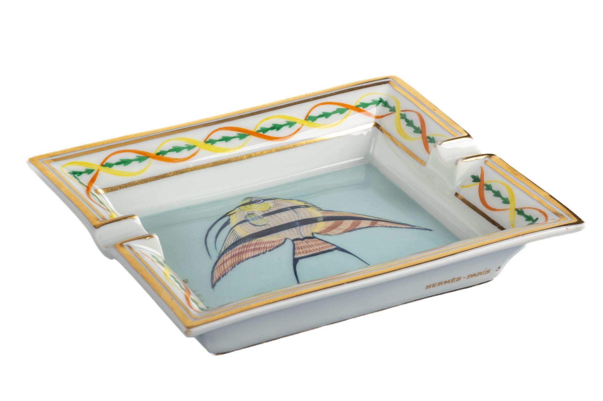 Hermes signature ashtray with fish design in celesteand gold. Suede stamped bottom. Minor wear on it. Made in France. Minor chip on one corner.