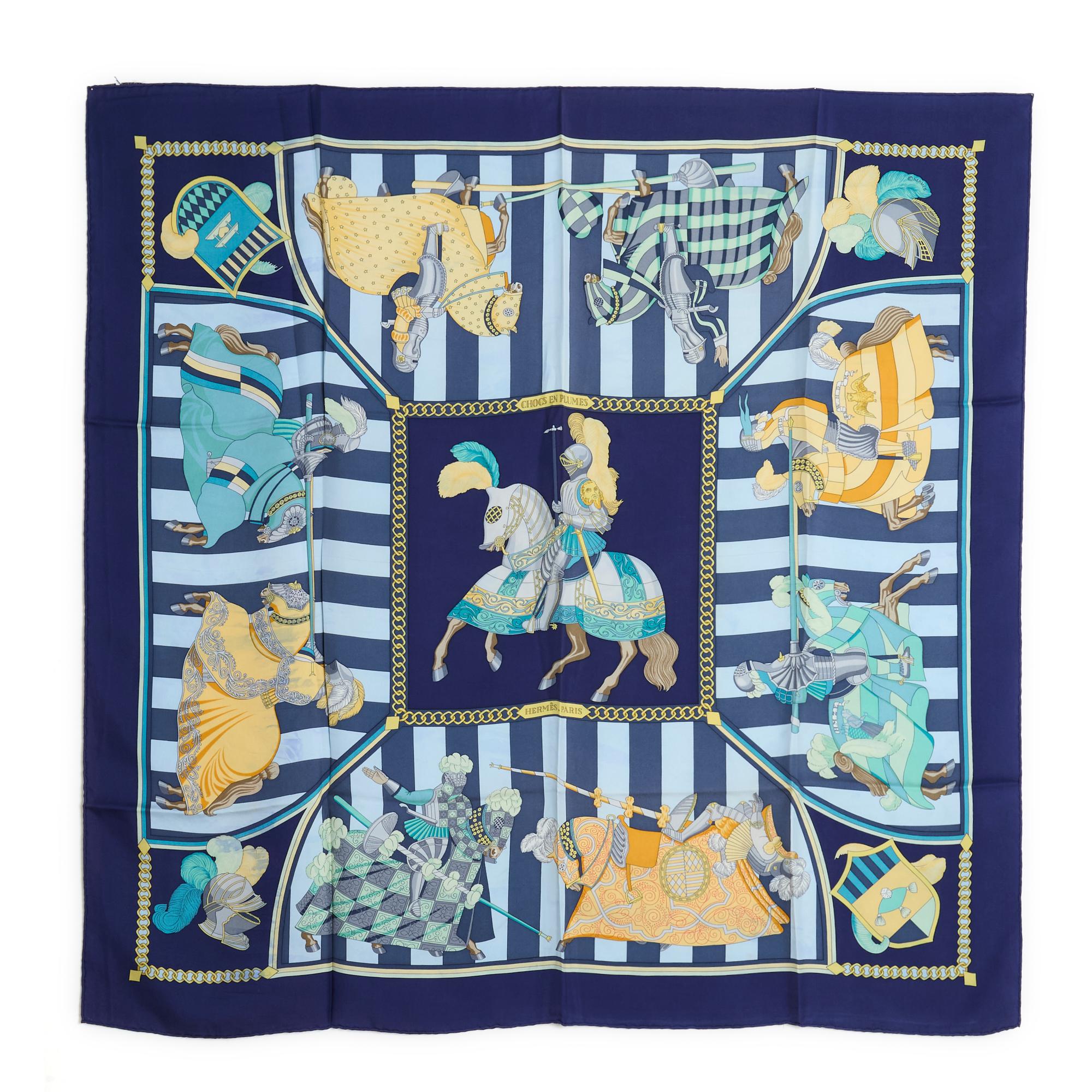 Hermès square scarf 90 in silk twill, Chocs en plume pattern by Christiane Vauzelles, published in 1993, reissued in 1996, patterns in blue and gold tones on blue stripes, navy blue edges. Width 90 cm x length 90 cm approximately. The square is