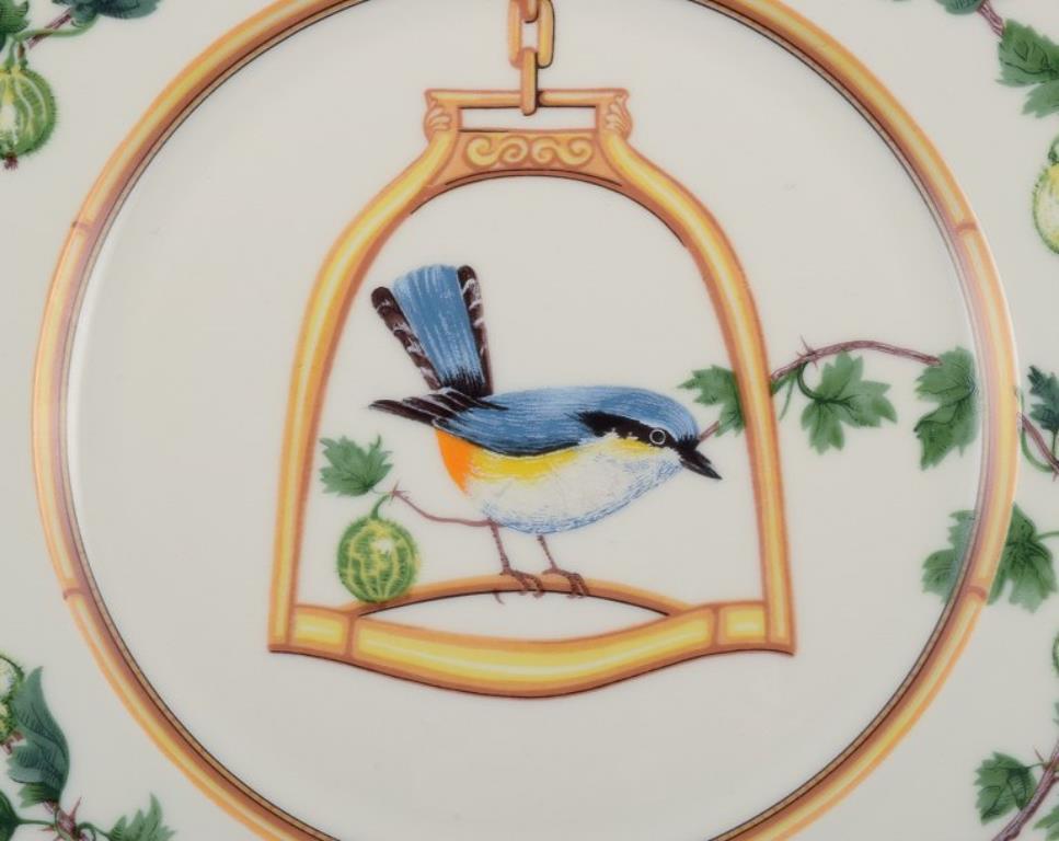 Porcelaine Hermès, France. Deux assiettes en porcelaine à motifs d'oiseaux. Fin du 20e siècle. en vente