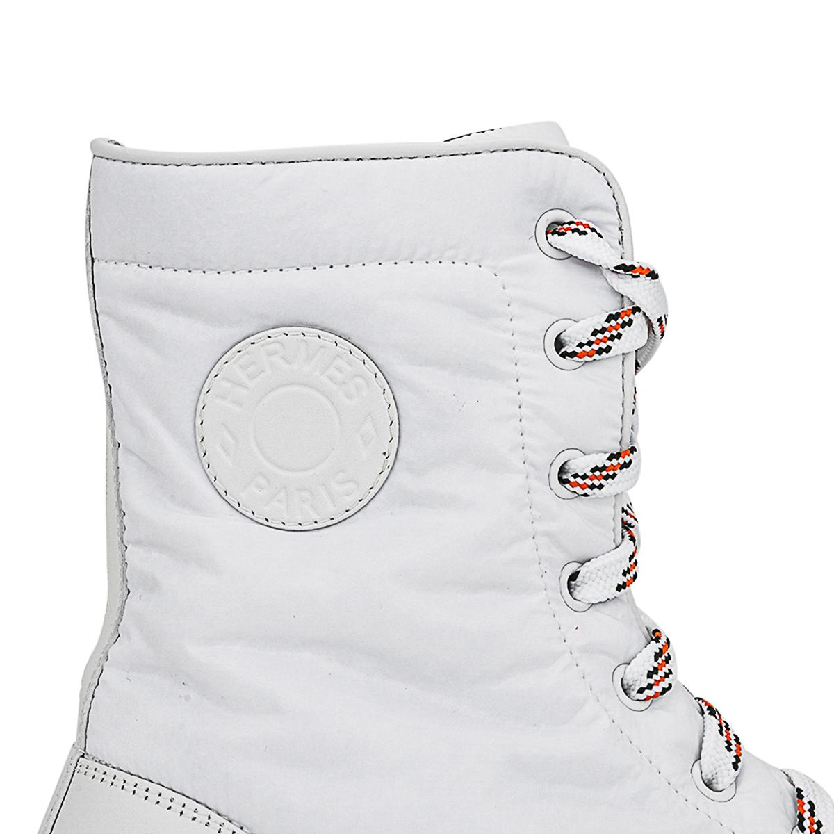 Mightychic offers a pair of Hermes Fresh Ankle Boots featured in White.
Round, White leather Clou de Selle plaque.
Water repellent parachute fabric boot with calfskin toe cap.
White laces with orange and black design.
Chic and sporty.
White rubber