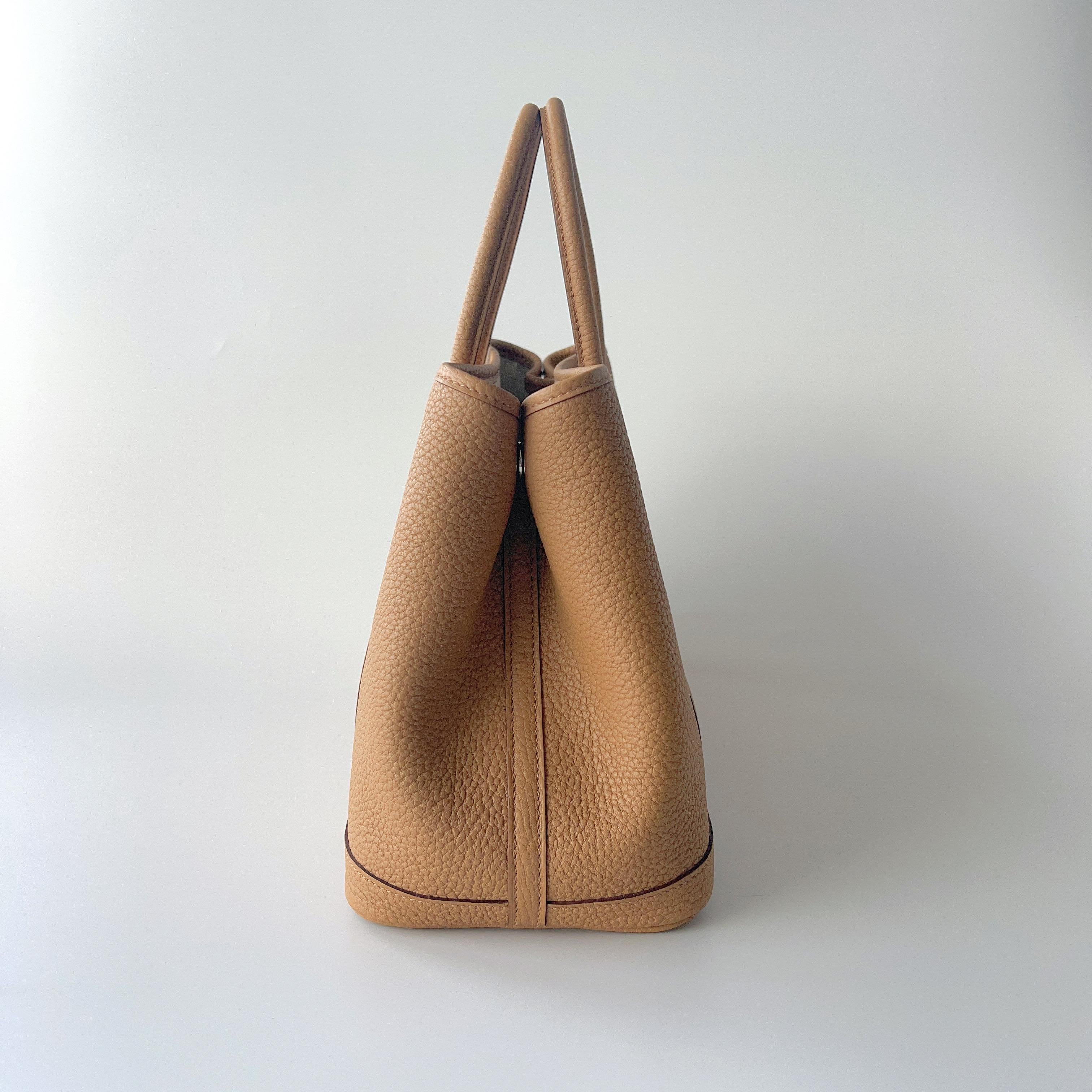 Shop this elegant Hermès Garden Party 30 in the warm caramel colour of Biscuit. Imagine the colour to being close to a digestive biscuit. It is in the Negonda Leather. This beautiful shade of warm neutral perfection, and is the perfect about town