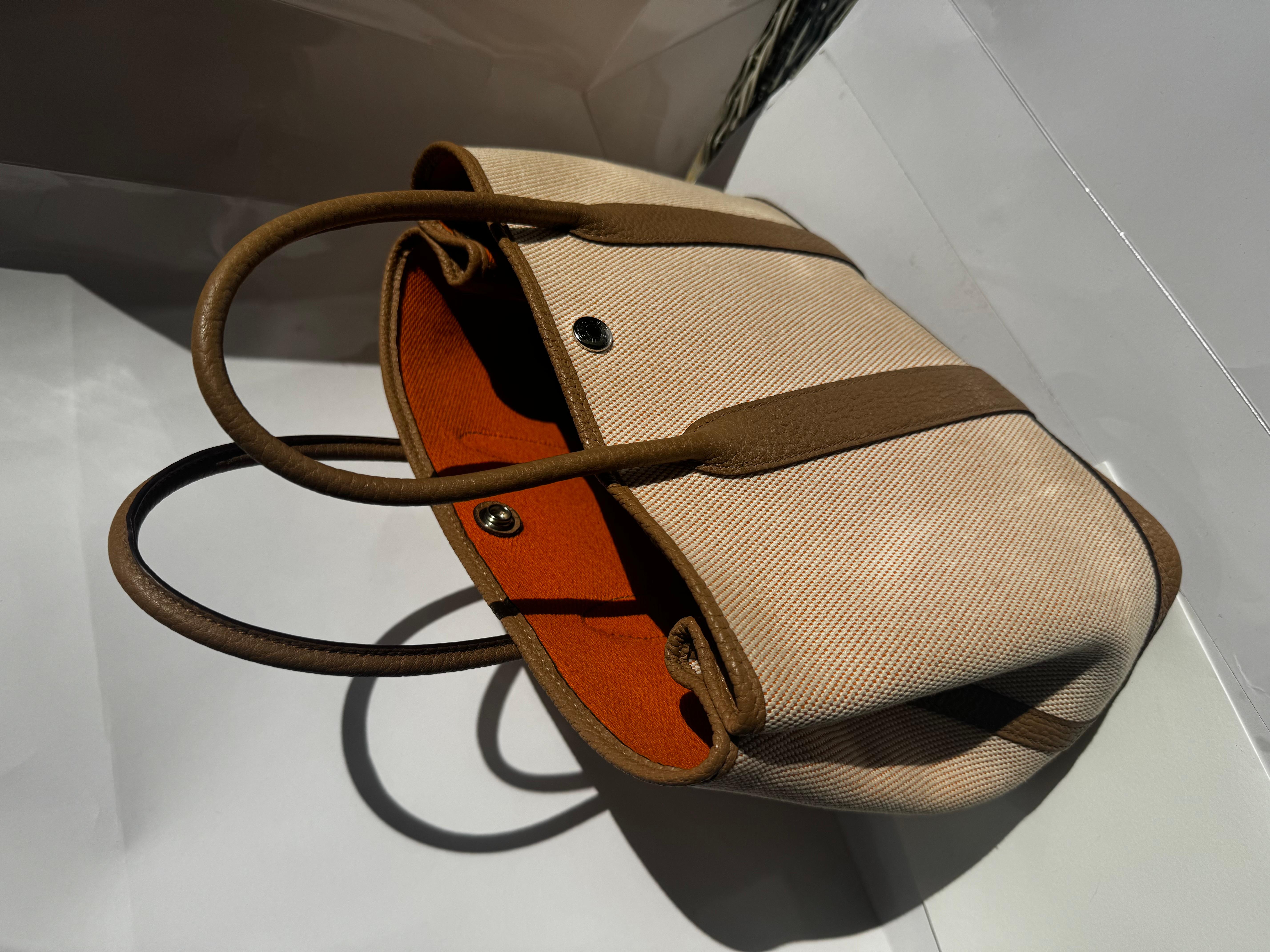 HERMES GARDEN PARTY 30 AUS ECRUFARBENEM CANVAS UND ABRICOTFARBENEM NEGONDA-LEDER.
Wir haben eine elegante Hermes Garden Party 30 In Ecru Twill H Canvas und Abricot Negonda. Es ist eine elegante, schlichte Tasche mit einem sportlicheren, lässigeren