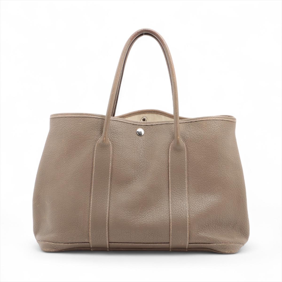 Die Hermès Garden Party 36 PM aus Negonda-Leder und in der Farbe Etoupe ist eine raffinierte und dennoch lässige Tasche, die mühelos Luxus mit Alltagstauglichkeit verbindet. Die mittelgroße (36 cm) Tasche aus strapazierfähigem, genarbtem