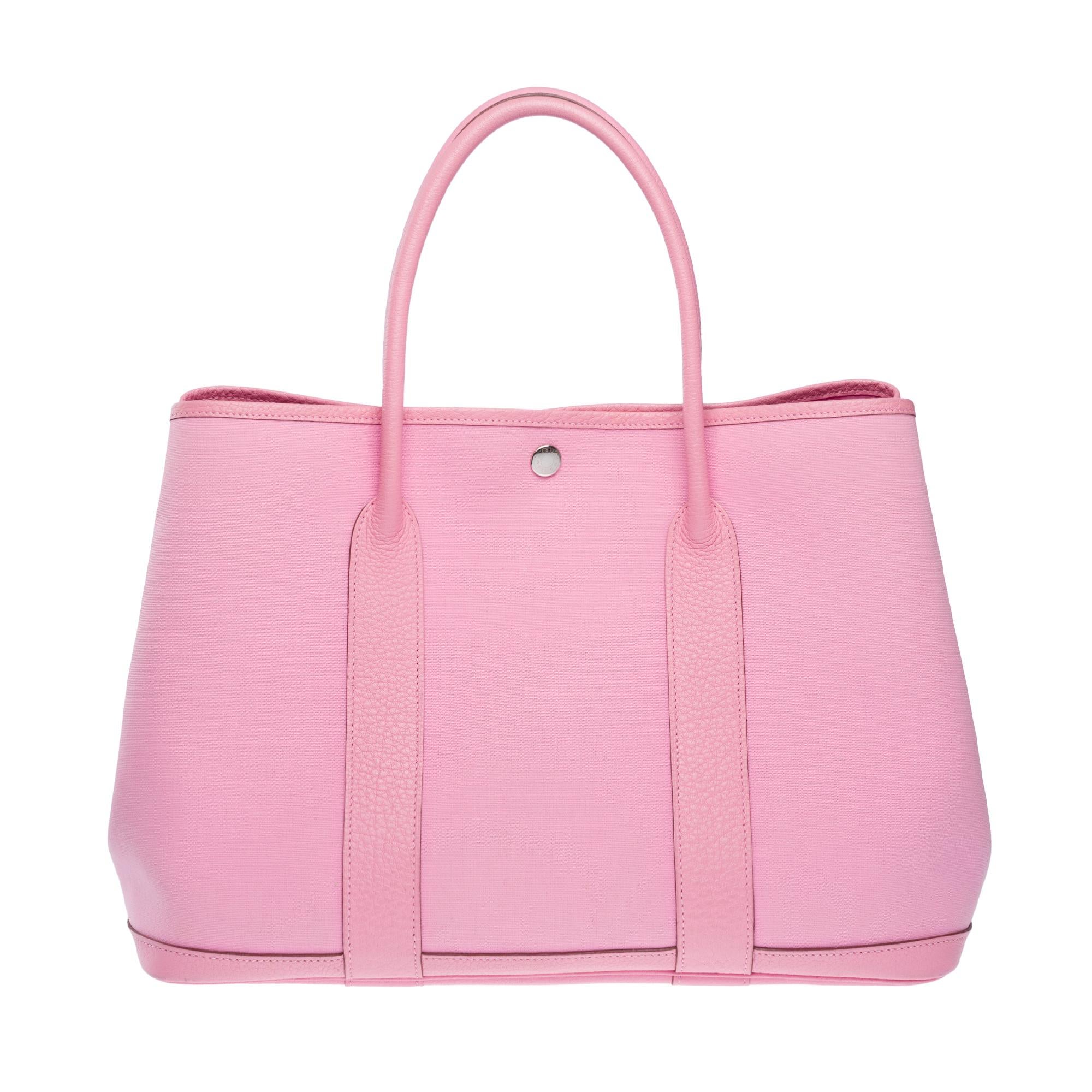 Beautiful​ ​Hermes​ ​Garden​ ​Party​ ​36​ ​cm​ ​Tote​ ​bag​ ​in​ ​Pink officer​ ​canvas​ ​and​​ ​Taurillon​ ​leather,​ ​with​ ​double​ ​pink​ ​leather​ ​handles​ ​for​ ​hand​ ​or​ ​shoulder​ ​carry

Silver​ ​metal​ ​saddle​ ​nail​ ​motif​ ​snap​