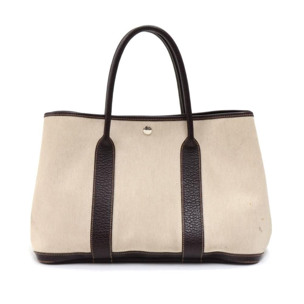 Hermes canvas and leather Garden Party PM Bag. Famous bag secured with silver tone stud in the middle and there are stud on each side as well. Hand held with great capacity simply stunning. HERMES PARIS is engraved on all the studs. SKU: HA889

Made
