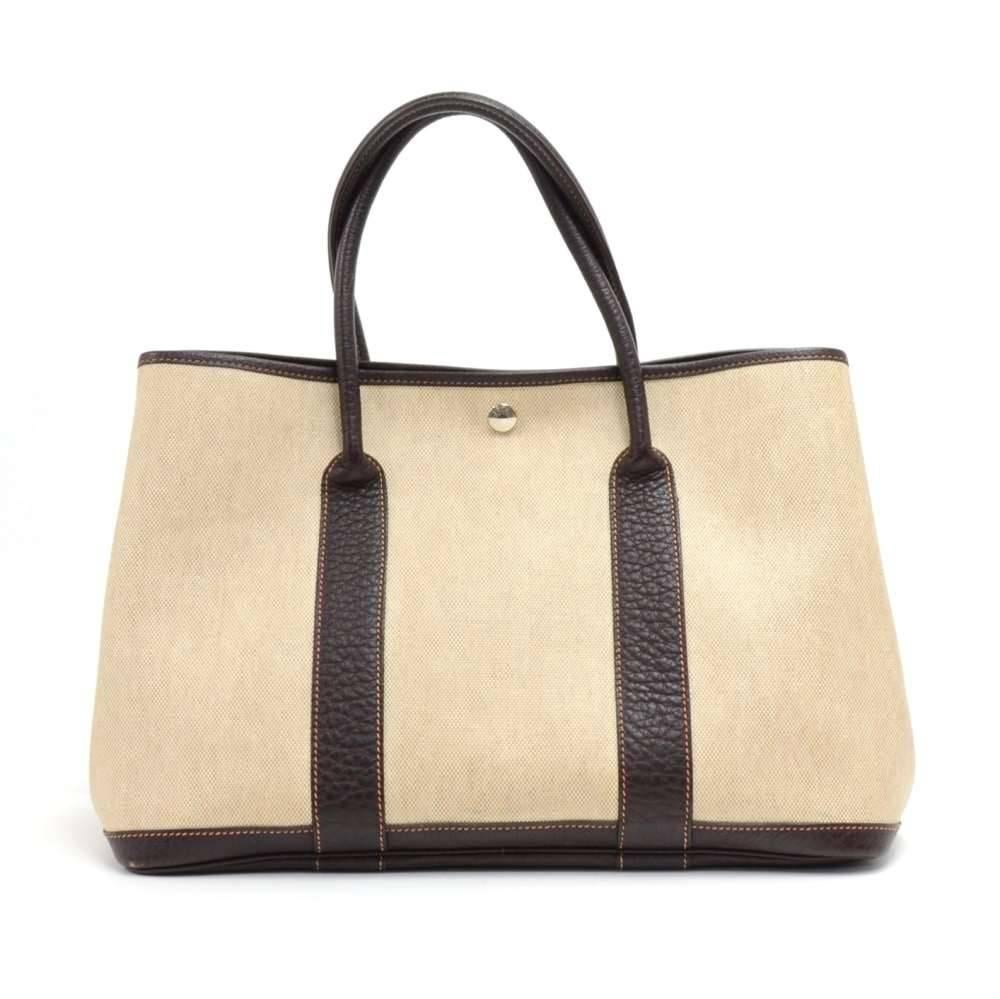 Hermes canvas and leather Garden Party PM Bag. Famous bag secured with silver tone stud in the middle and there are stud on each side as well. Hand held with great capacity simply stunning. HERMES PARIS is engraved on all the studs. SKU: HA896

Made