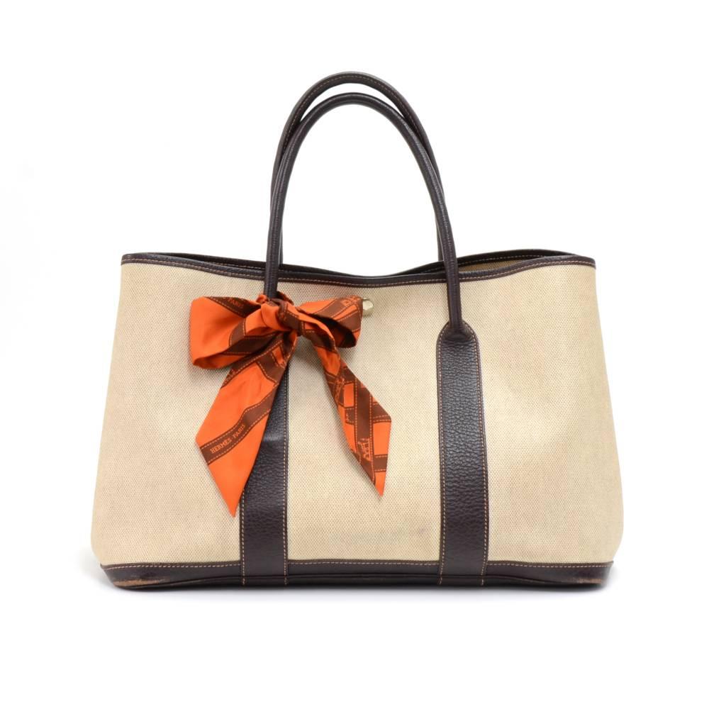 Hermes canvas and leather Garden Party PM Bag. Famous bag secured with silver-tone stud in the middle and there are stud on each side as well. Hand held with great capacity simply stunning. HERMES PARIS is engraved on all the studs.Comes with a