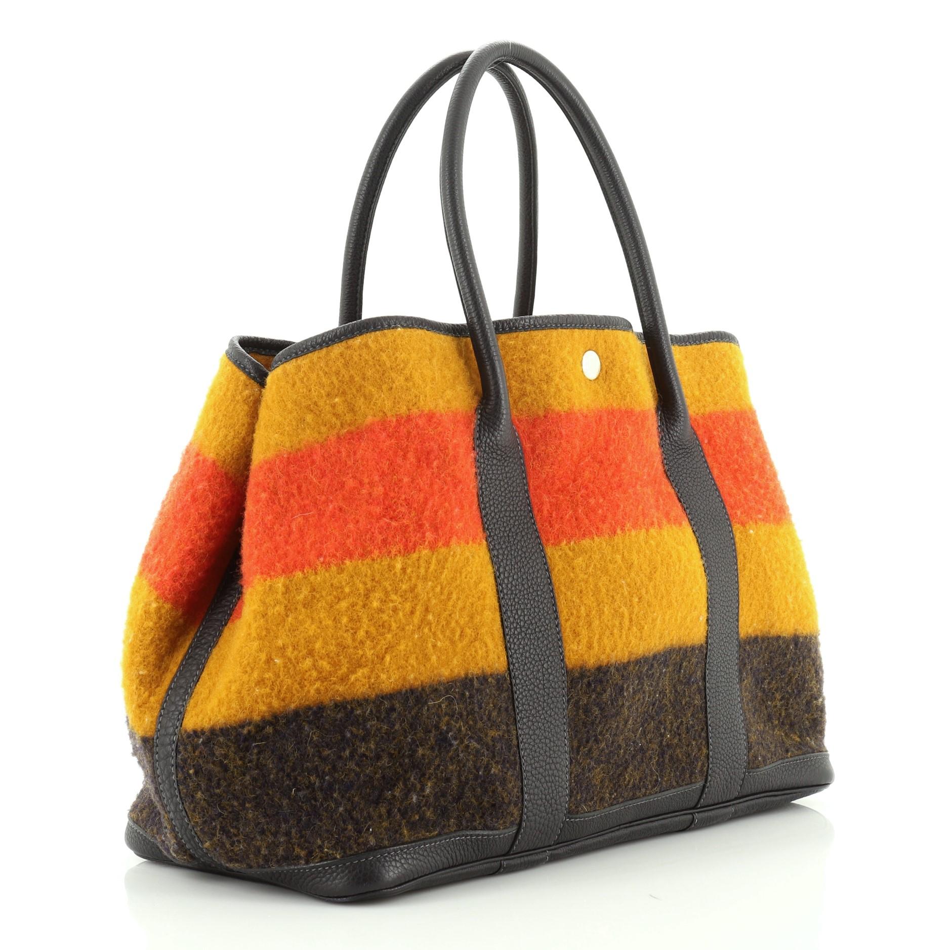 This Hermes Garden Party Tote Rocabar and Leather 36, crafted in Multicolor Rocabar and Indigo Negonda leather, features tall rolled handles and palladium hardware. Its snap closure opens to a Multicolor Rocabar interior. Date code reads: F Square