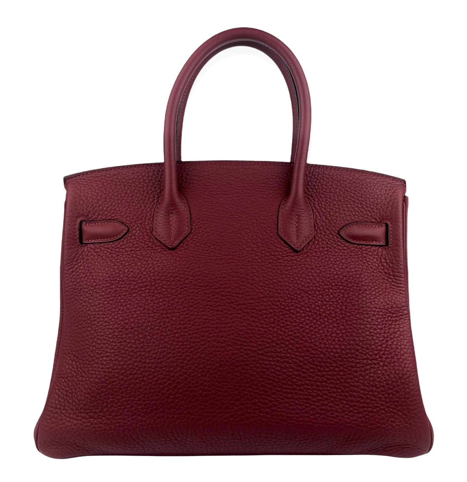 This authentic Hermès Garnet Red Clemence 30 cm Birkin is in pristine unworn condition with the protective plastic intact on the gold hardware.  Hermès bags are considered the ultimate luxury item the world over.  Hand stitched by skilled craftsmen,