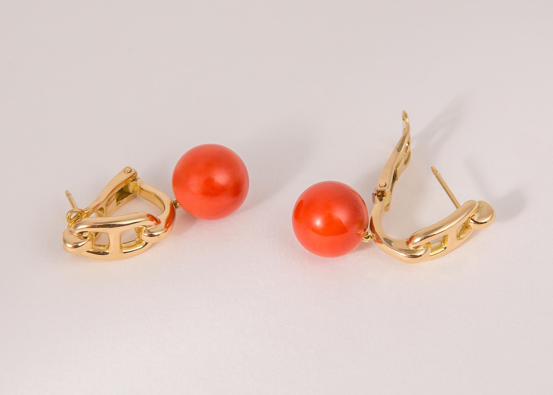 Founded in France in 1837 Hermes is known worldwide for their exclusive style and quality. Rich 18k gold and vivid orange coral ( 12.75mm ) create this simply chic earring. 1 3/8's in length