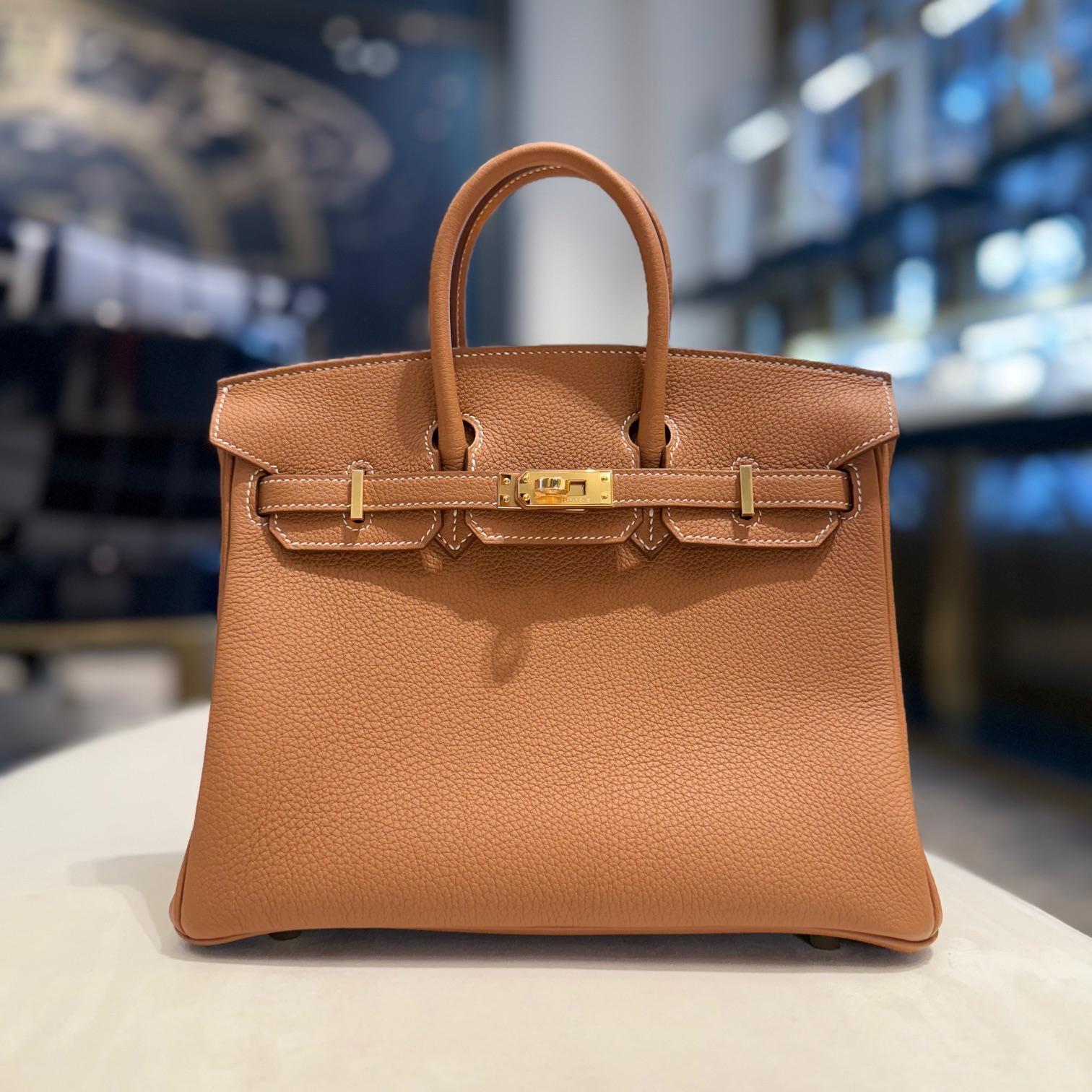 Jewels Aficionado offers the Hermès Gold Birkin 25 in Togo leather, a timeless classic with a refined yet effortless appeal. The warm caramel brown hue, accented by signature contrast stitching, enhances the bag’s versatility. Crafted from durable