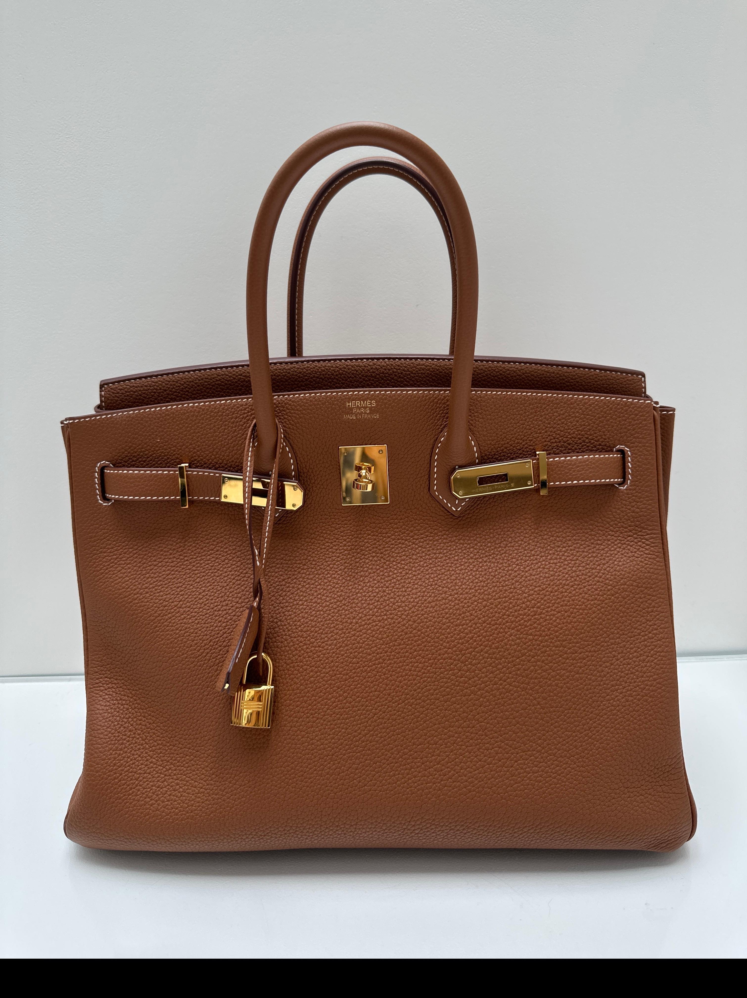 Borsa Birkin 35 in oro di Hermes. Pelle togo dorata con finiture in oro giallo. Cuciture bianche a contrasto su pelle color oro. Interni puliti. La combinazione più ricercata. Borsa più recente. Include clochette, lucchetto, chiavi e sacchetto