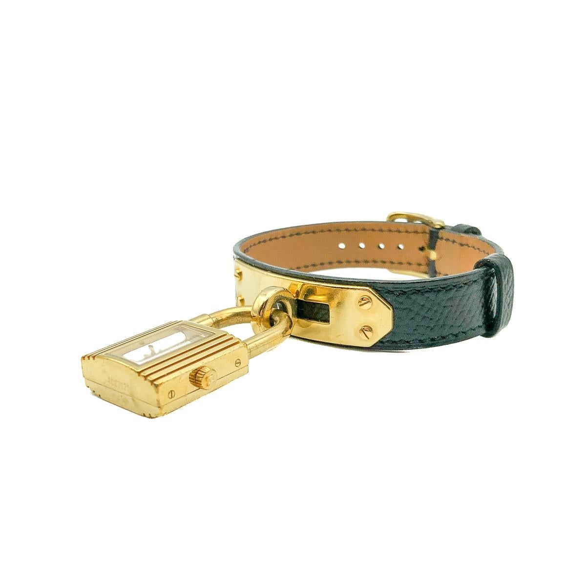 An iconic Hermès Kelly Bracelet Watch dating to the year 2000. Crafted in gold plated brass and black calf leather with a white face. In excellent vintage condition, carrying the full suite of marks, serviced by a registered watchmaker and fitted