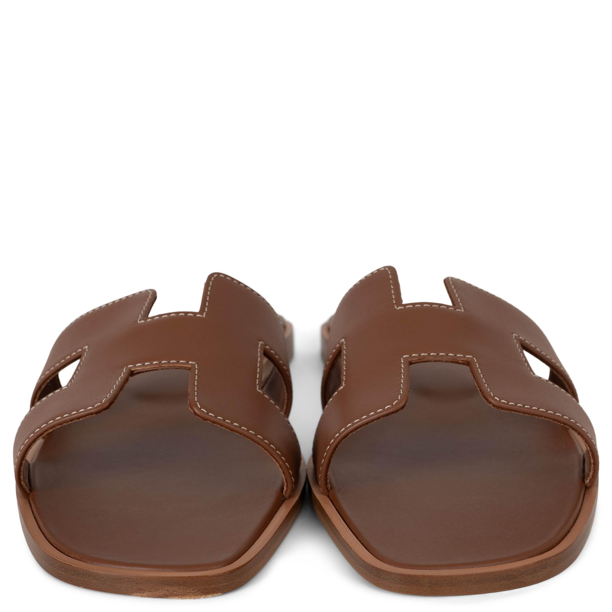 This 100% authentic Hermès Oran slide sandals in Gold (camel) Box calfskin leather epitomize timeless elegance and effortless style. Featuring the iconic H cut-out, these sleek slides showcase the brand’s signature craftsmanship. A versatile staple,