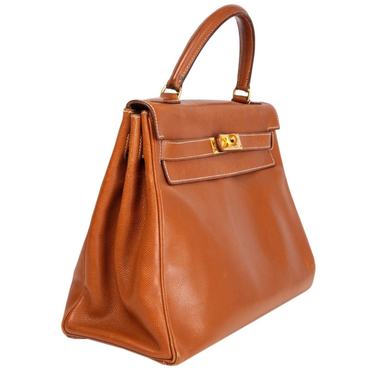 Hermes 'Kelly I 32 Retourne' bag in Gold (camel) Veau Courchevel leather with contrasting white stitching. Lined in Chevre (goat skin) with two open pockets against the front and a zipper pocket against the back. Has been carried with overall signs