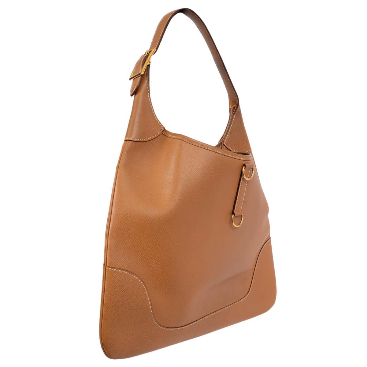 100% authentic Hermès Trim 37 hobo in Gold (camel) Courchevel leather featuring gold-tone hardware. Lined in beige suede with one zipper pocket against the back and one open pocket against the front. Has been carried and shows some faint wear to the
