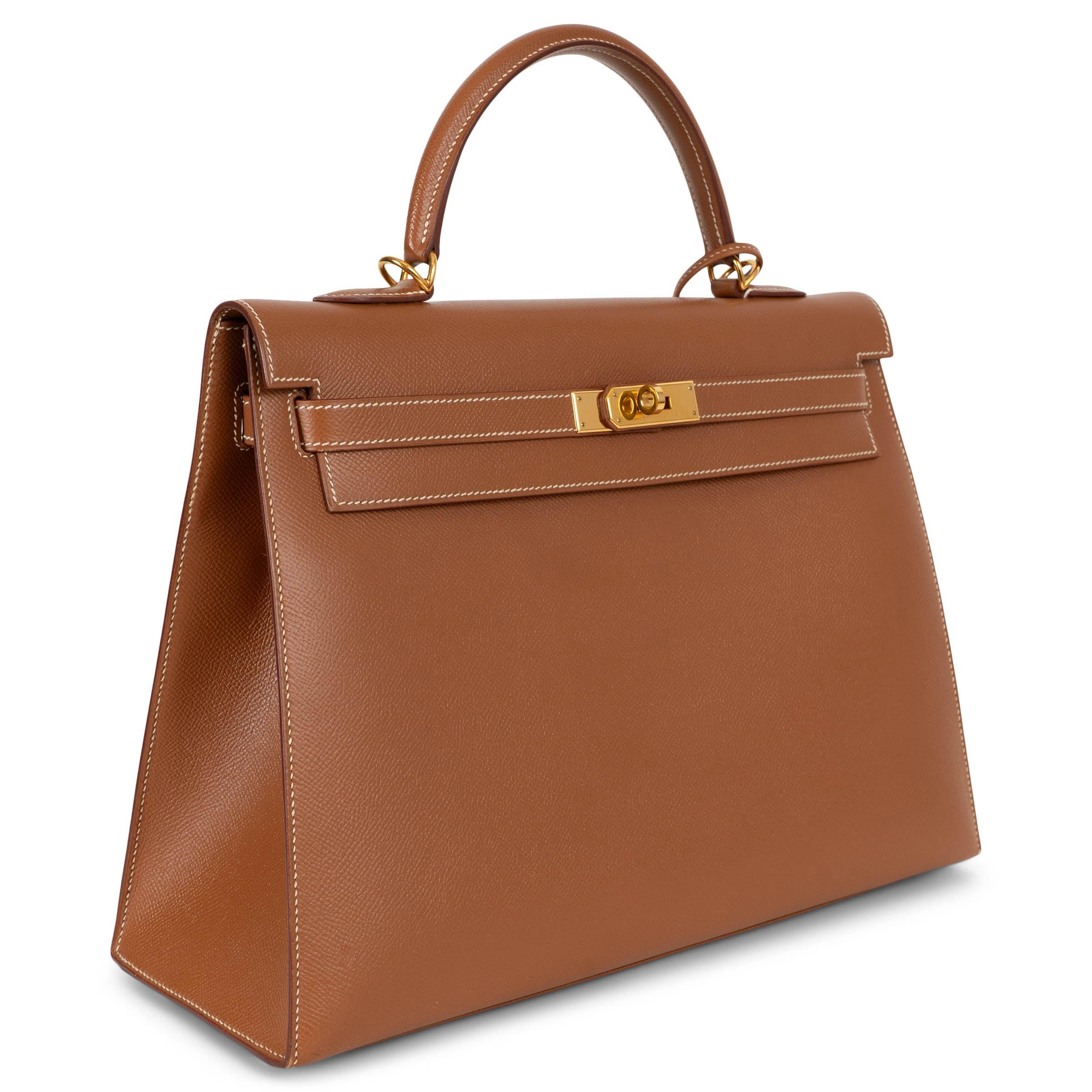 Questa borsa Hermès Kelly 35 Sellier, autentica al 100%, è realizzata in pelle Veau Epsom color oro (cammello) con cuciture bianche a contrasto e rifinita con hardware placcato oro. Presenta la tipica silhouette strutturata della maison e l'iconica