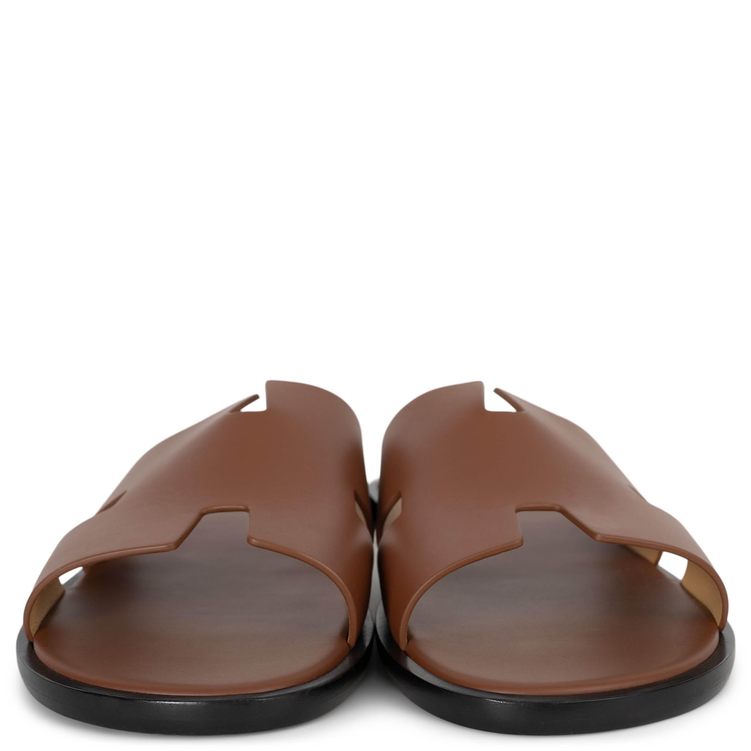 This 100% authentic Hermès Izmir slide sandals in Gold (camel) calfskin leather are a timeless expression of effortless luxury. Featuring the iconic H cut-out design, they offer a sleek yet relaxed aesthetic. The raw edge detail adds a refined