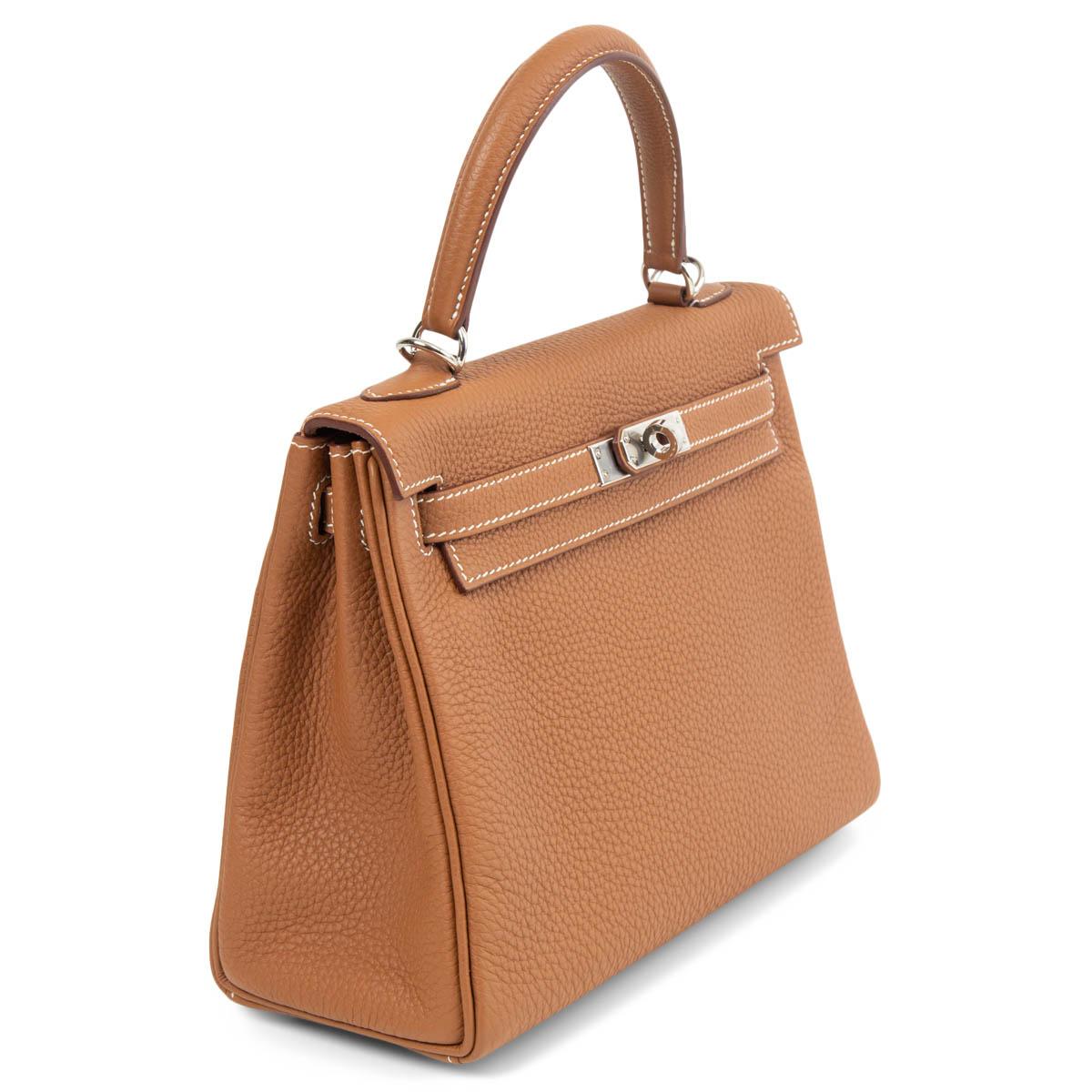 100% authentic Hermès Kelly 25 Retourne bag in Gold (camel brown) Veau Togo leather featuring palladium hardware. Lined in Chevre (goat skin) with an open pocket against the front and a zipper pocket against the back. Brand new. Full Set.