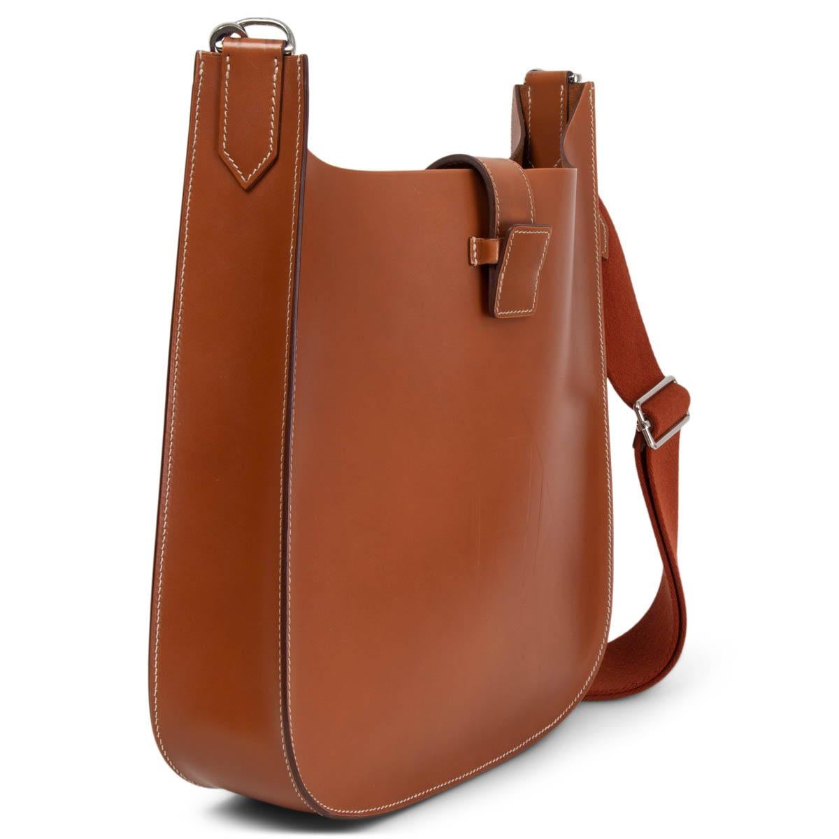 100% authentic Hermès Evelyne 29 Sellier crossbody bag in Gold (cognac brown) Vache Hunter leather. Features a canvas crossbody strap, an embossed Hermes H at the front and palladium hardware. The top opens to a matching suede interior with an