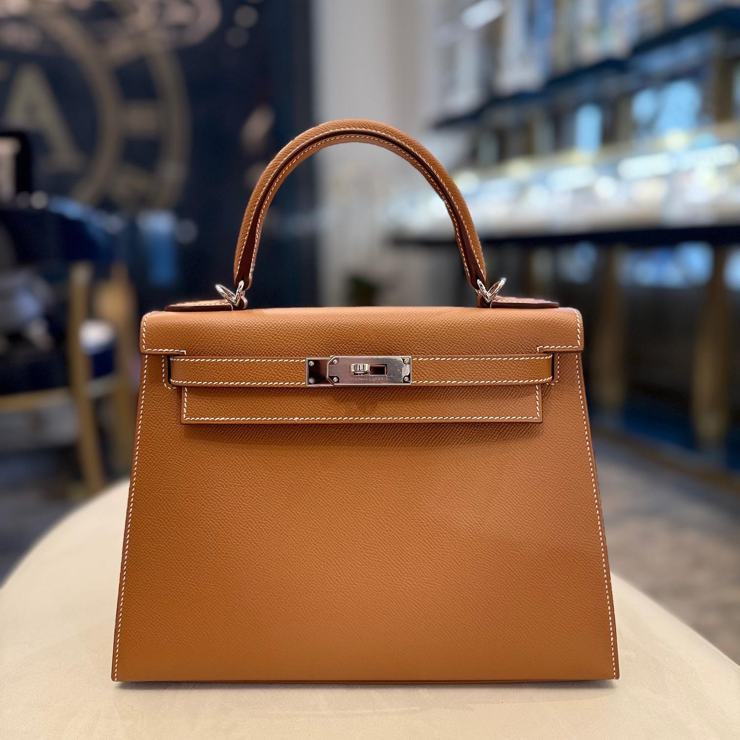 Jewels Aficionado offers The Hermès Kelly Sellier 28 in Gold Epsom leather is a timeless classic, combining structure with sophistication. Its warm Gold hue enhances the sharp lines of the Sellier silhouette, while Epsom leather ensures durability