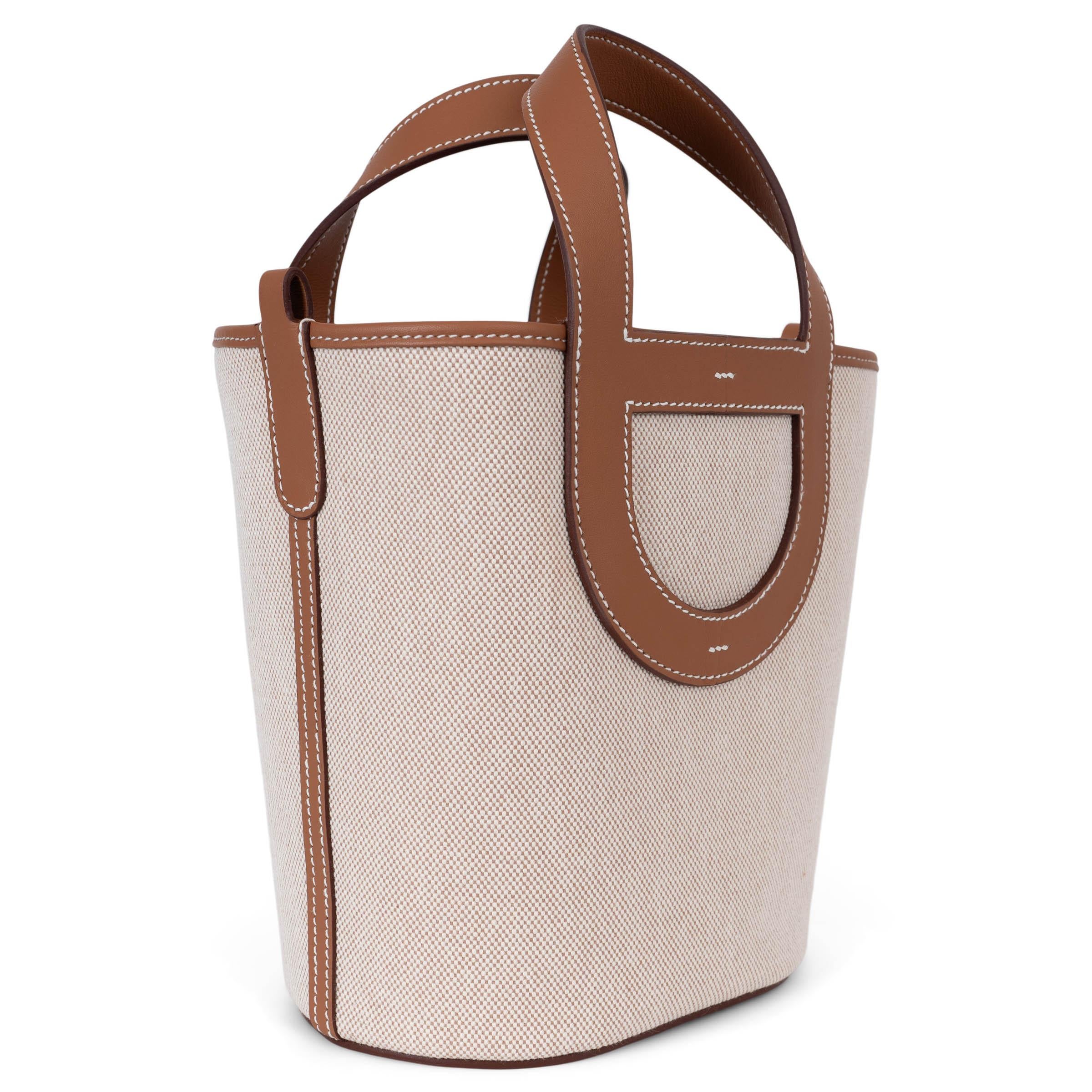 This 100% authentic Hermès In-the-Loop 18 bag in Écru-Beige Toile H canvas with Gold (camel) Veau Swift leather trims is a refined blend of casual elegance and craftsmanship. Accented with contrasting white stitching, it features signature Chaîne