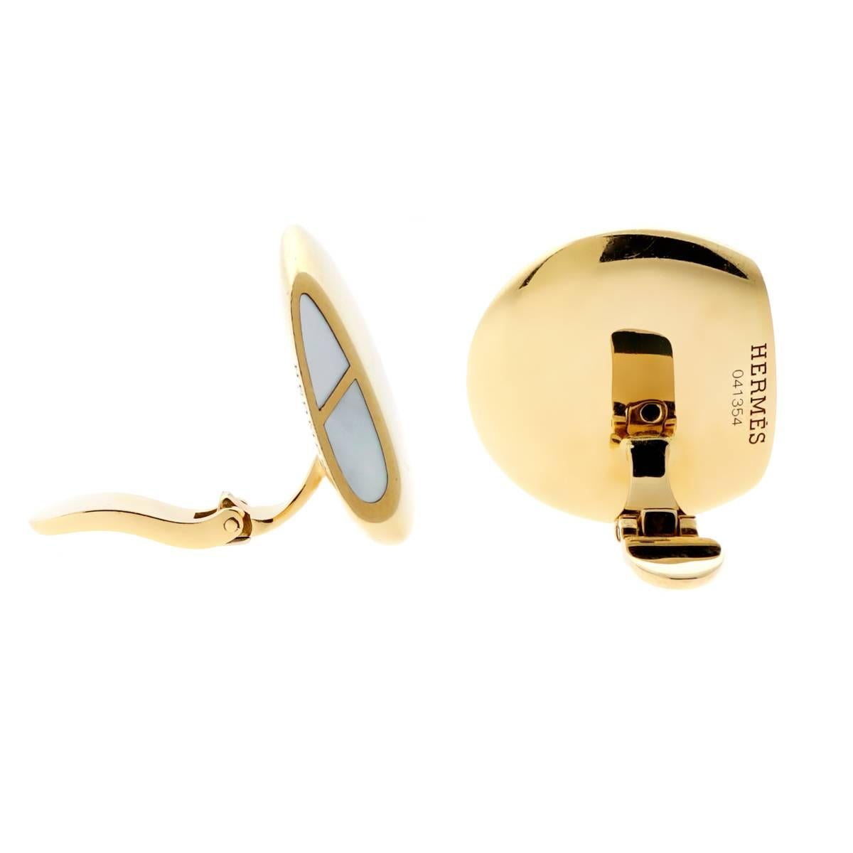 A fabulous pair of Hermes earrings featuring inlaid mother of pearl within a link motif in 18k yellow gold.

