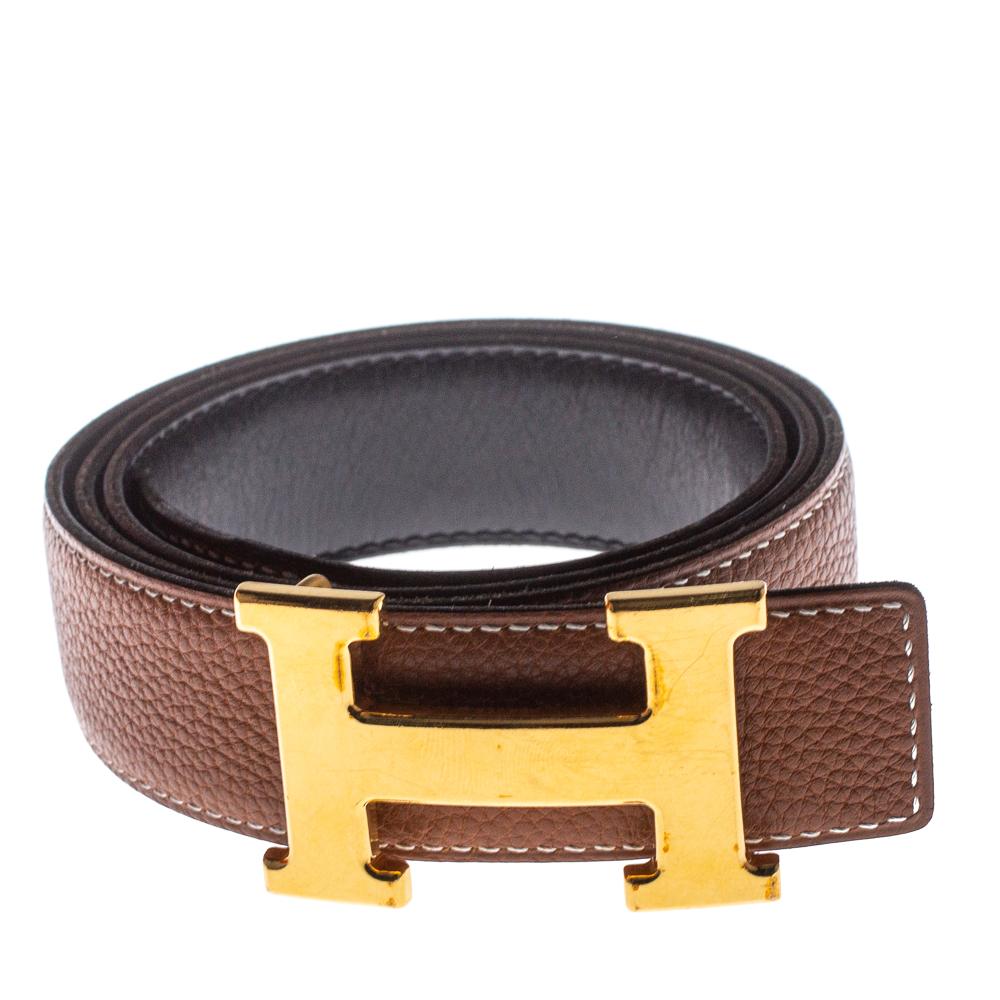 A classic add-on to your collection of belts is this Hermes piece in Togo and Swift leather. It is reversible with a black shade on one side and gold on the other. It is topped with an H buckle in gold-tone hardware. This wardrobe essential piece