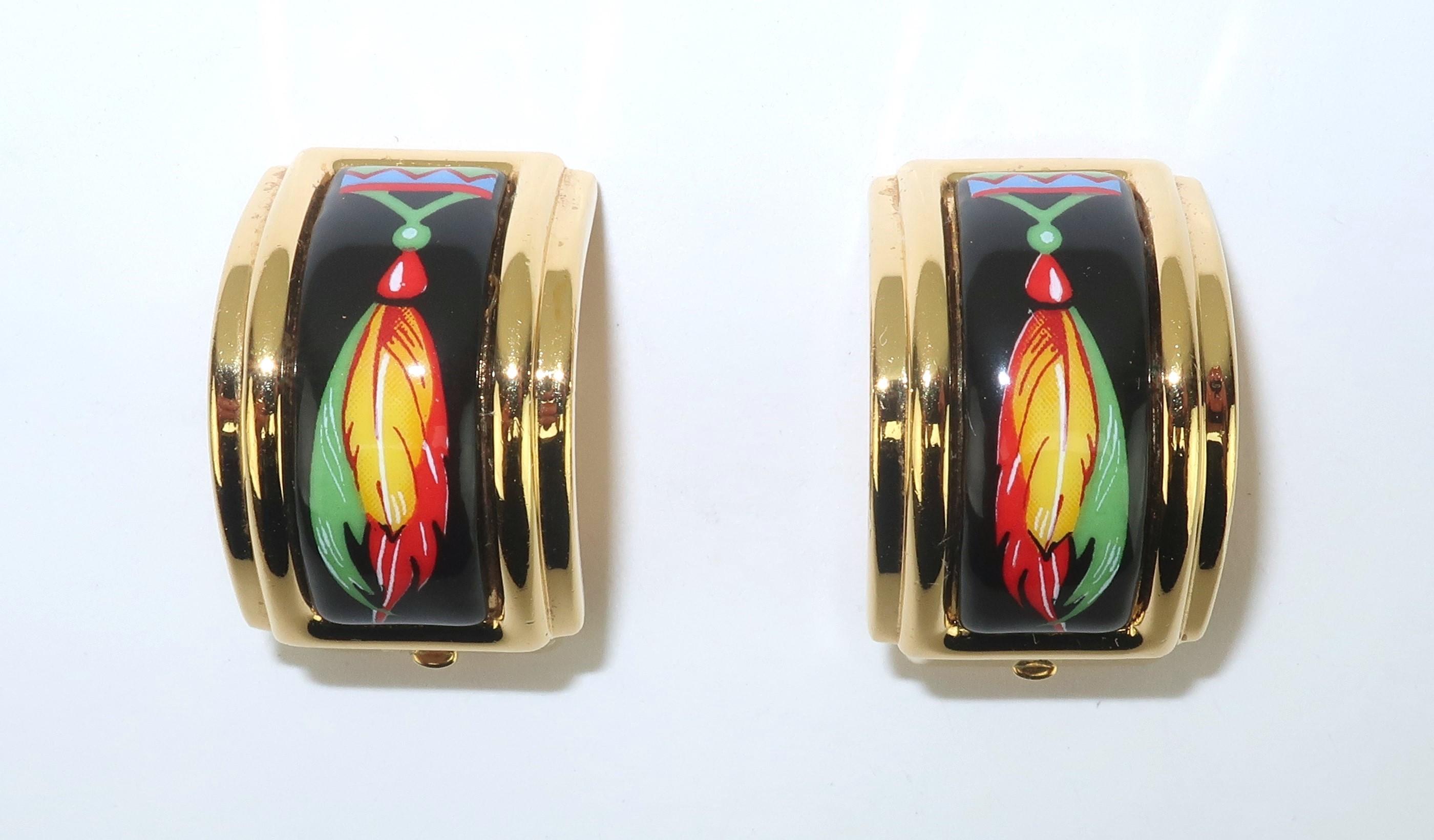 Boucles d'oreilles à clip en plaqué or Hermes avec un détail émaillé vibrant et magnifiquement graphique.  Les boucles d'oreilles ont une silhouette en demi-lune avec un clip en forme de 'H' stylisé... une petite touche amusante.  L'insert en émail