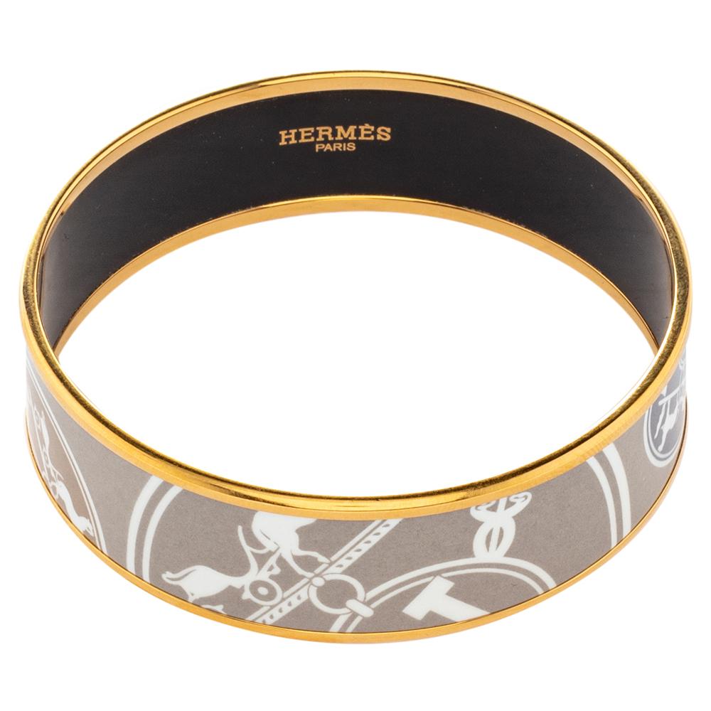 A style element to flaunt with pride is this one by Hermès. It is sculpted from gold-plated metal and designed with gorgeous enamel work. The bangle bracelet has the brand's stamp on the inner side of the band.