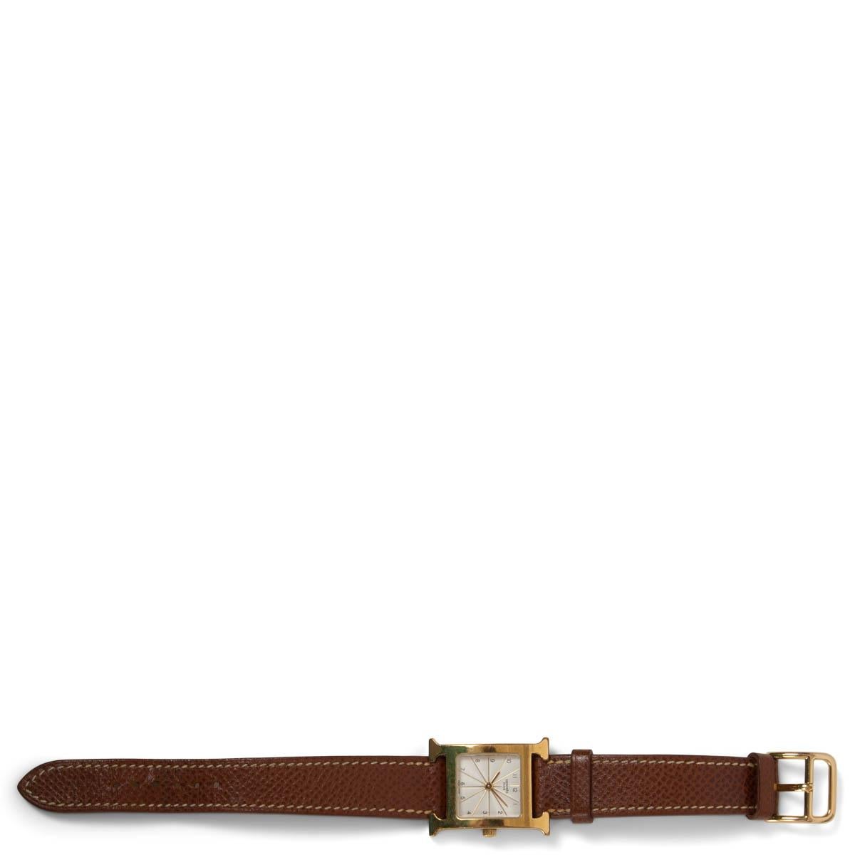 100% authentic Hermès 2001 Heute H 17.2 x 17.2 mm in yellow gold plated steel with off-white white dial, long interchangeable strap in brown Epsom calfskin. Quartz movement, Swiss Made. Has been worn and the leather strap shows some patina and