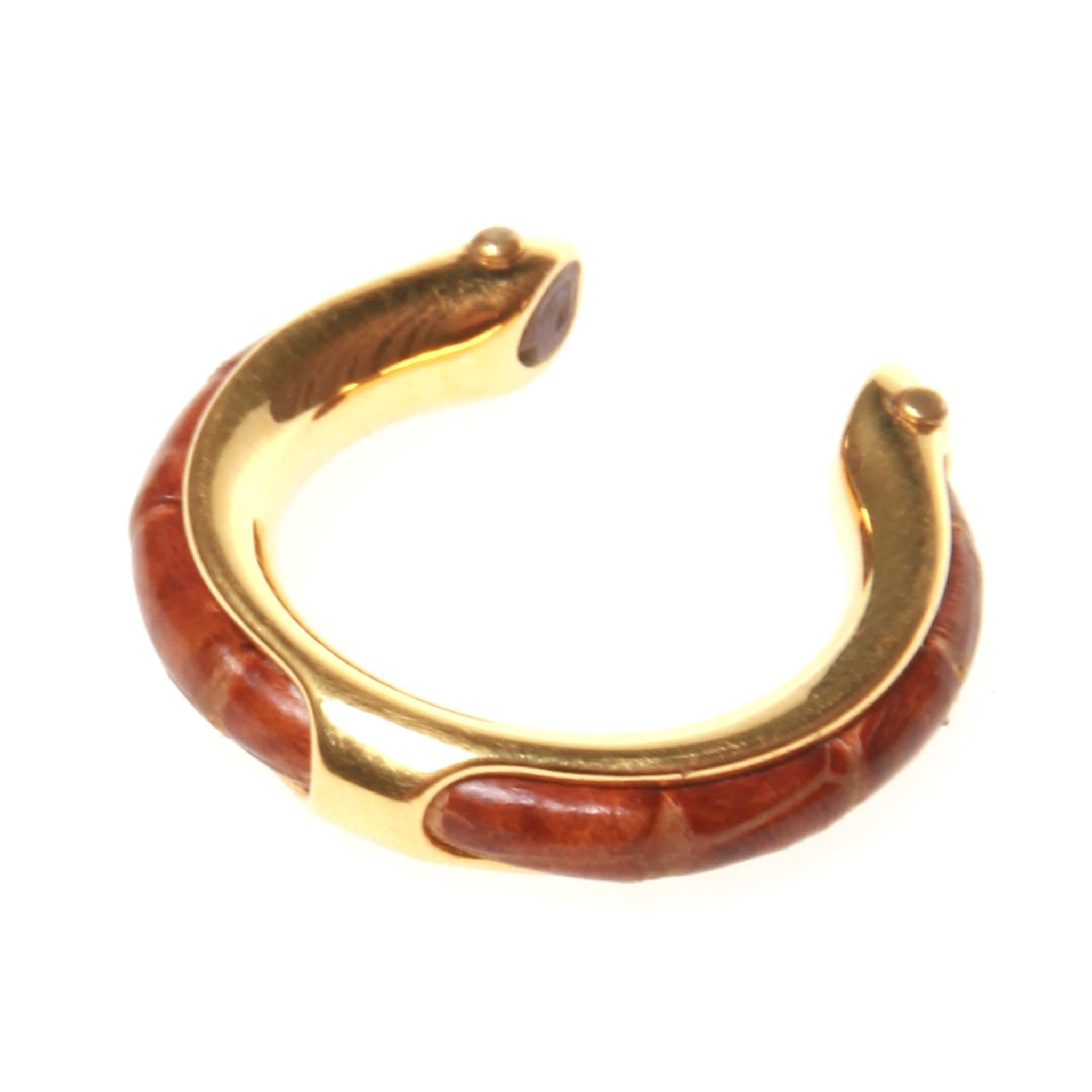 Hermes Paris gold horseshoe ring with a brown lizard leather detail.