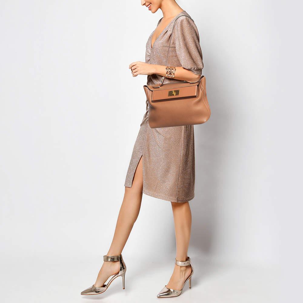 Die 24/24 von Hermès ähnelt der kultigen Kelly, hat aber einen entspannten, lässigen Ton. Ein Blick auf die Details: Die Tasche hat einen Henkel und einen Schulterriemen, einen charakteristischen Drehverschluss an der Klappe, eine Gesäßtasche und