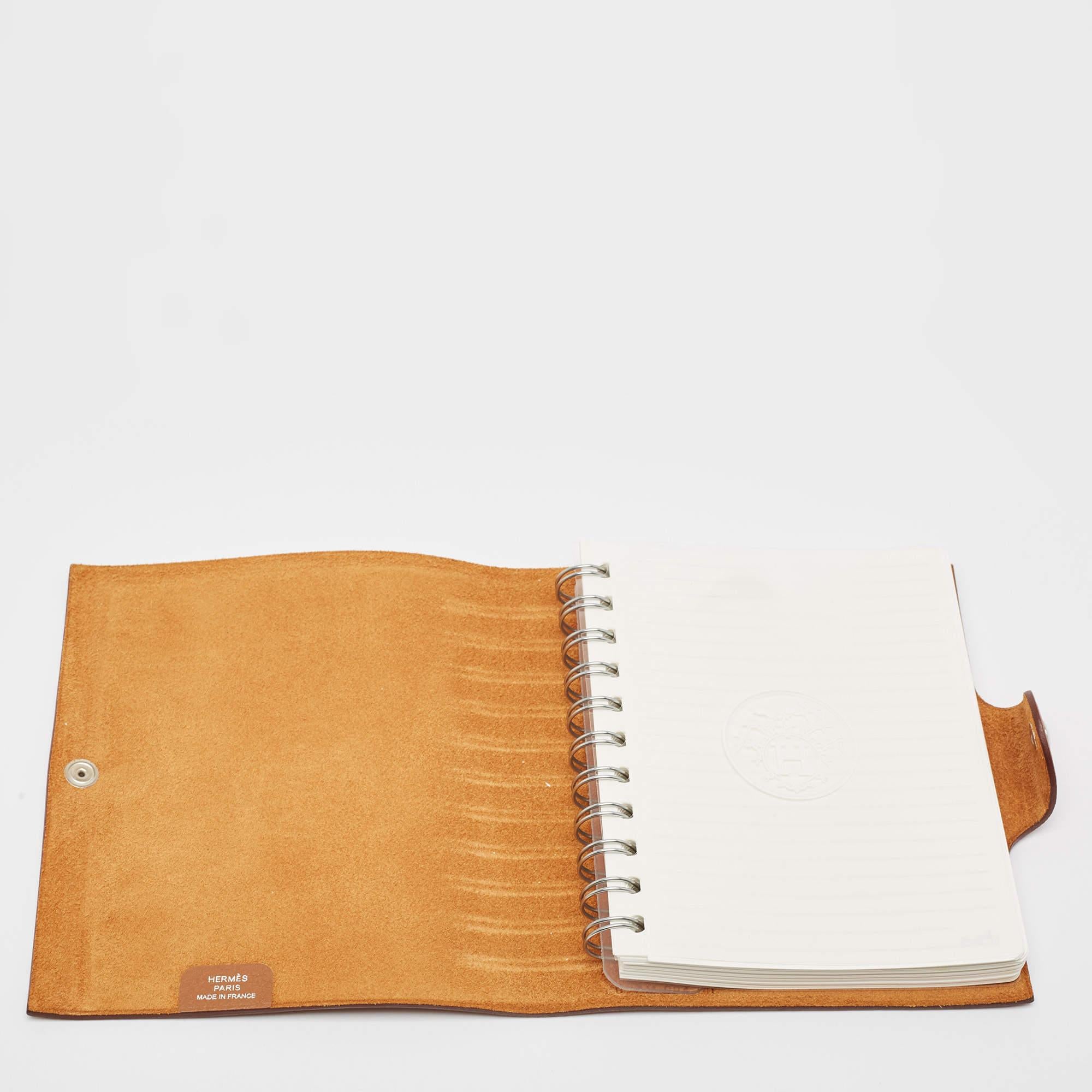 This Hermes Ulysse cover will instantly add style and charm to your favorite notebook. It has been crafted from Togo leather and comes with a snap fastener. Carry this to work or college for a statement making look.